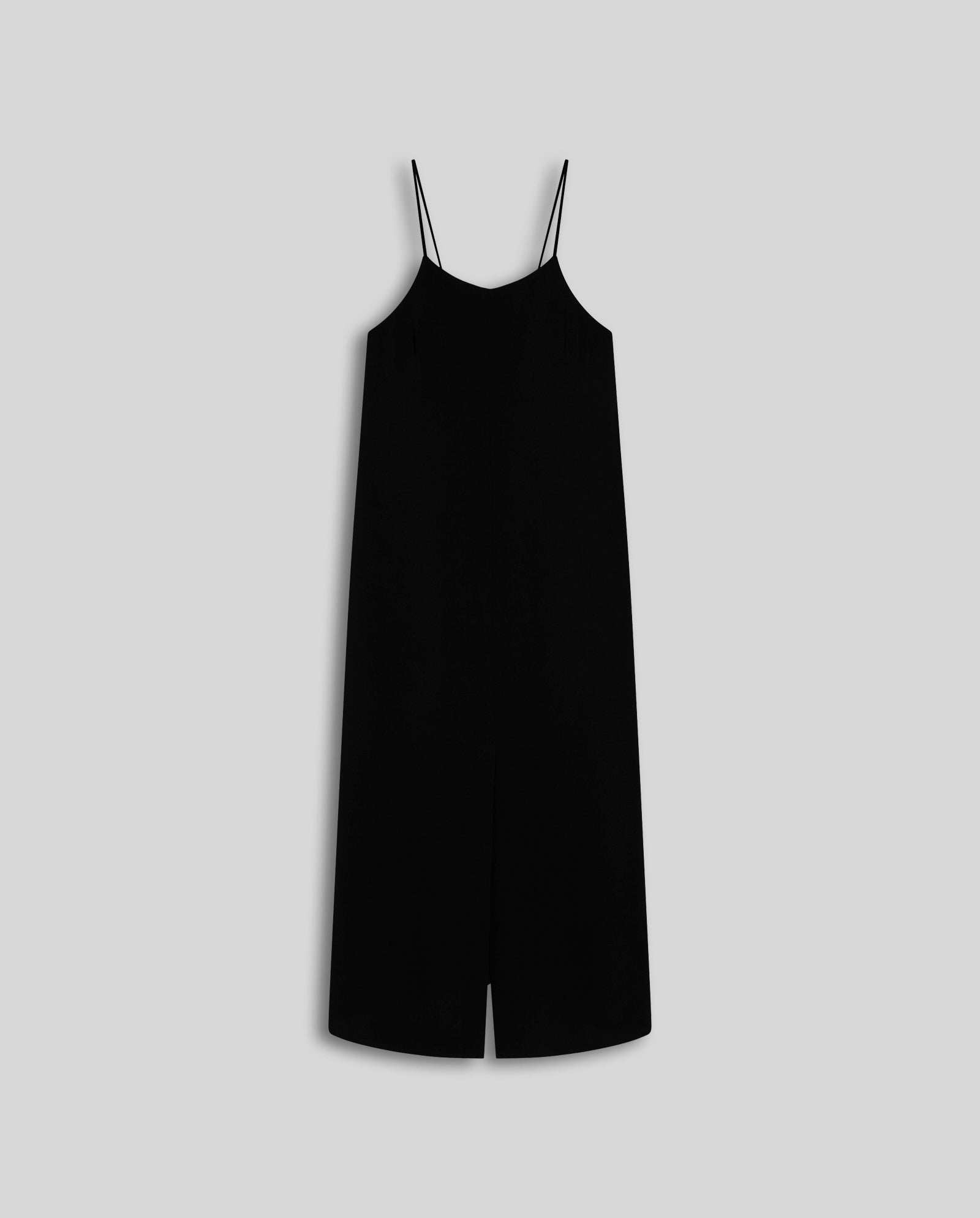 The NAVA Dress by IVY OAK is a sleeveless black slip dress with thin spaghetti straps, made from lightweight crepe fabric—an effortless warm-weather essential, shown on a plain light gray background.