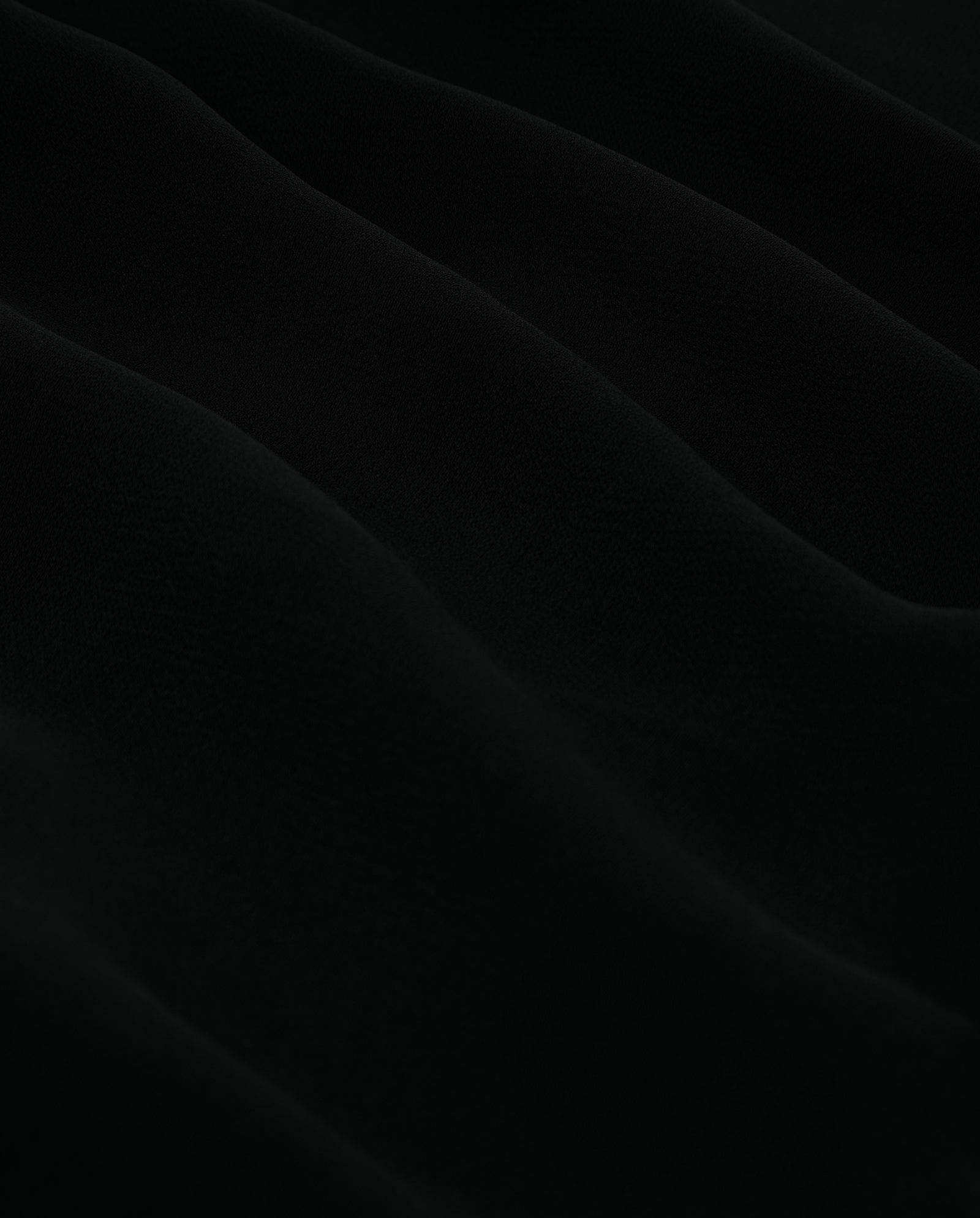 The NESTA Dress by IVY OAK features soft black crepe fabric with gentle, wavy folds and a subtle textured pattern—ideal for an elegant neckholder look.