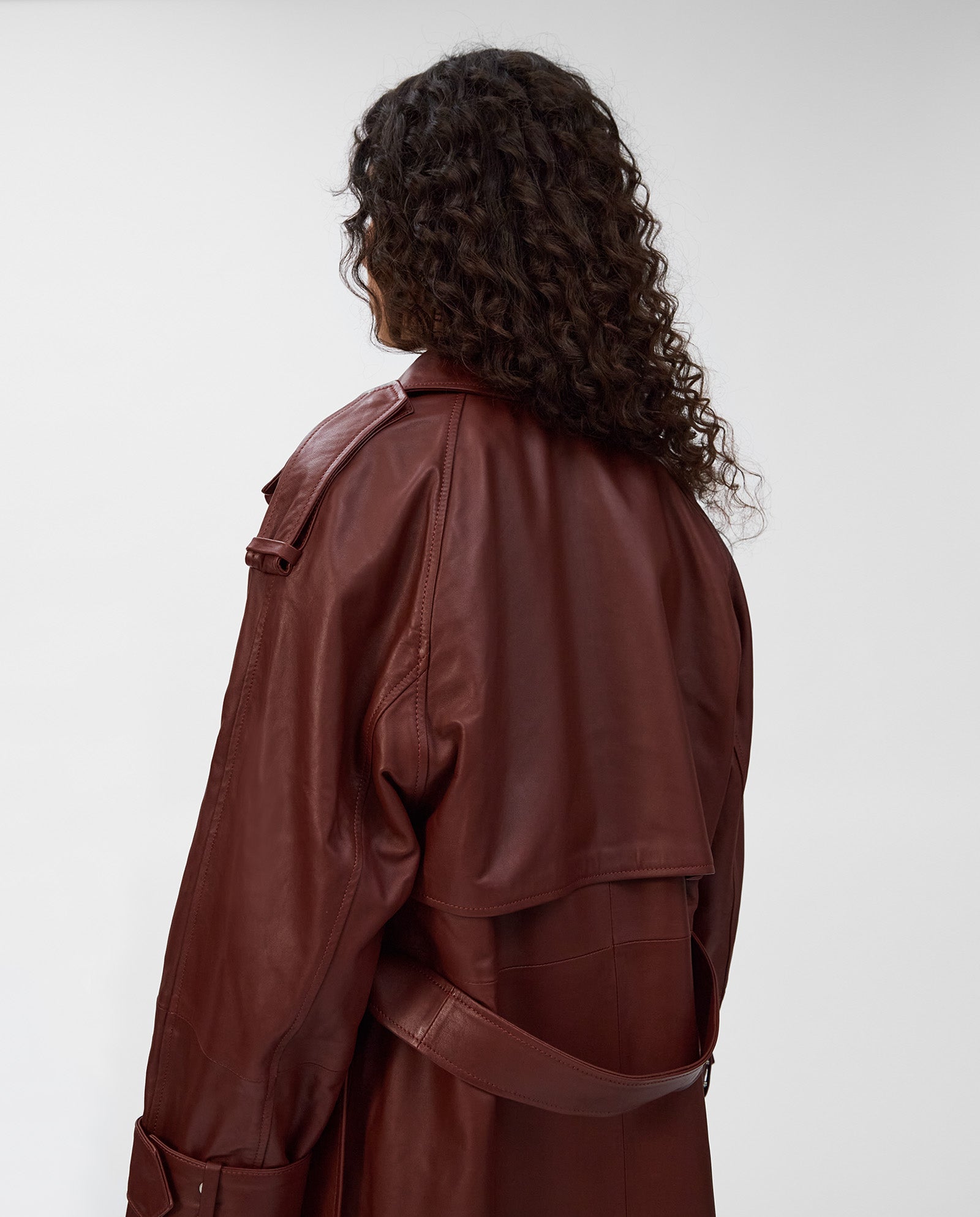 A person with long curly hair, shown from the back against a plain background, is wearing the IVY OAK LILITH Coat featuring a large collar, belt, and buckles.