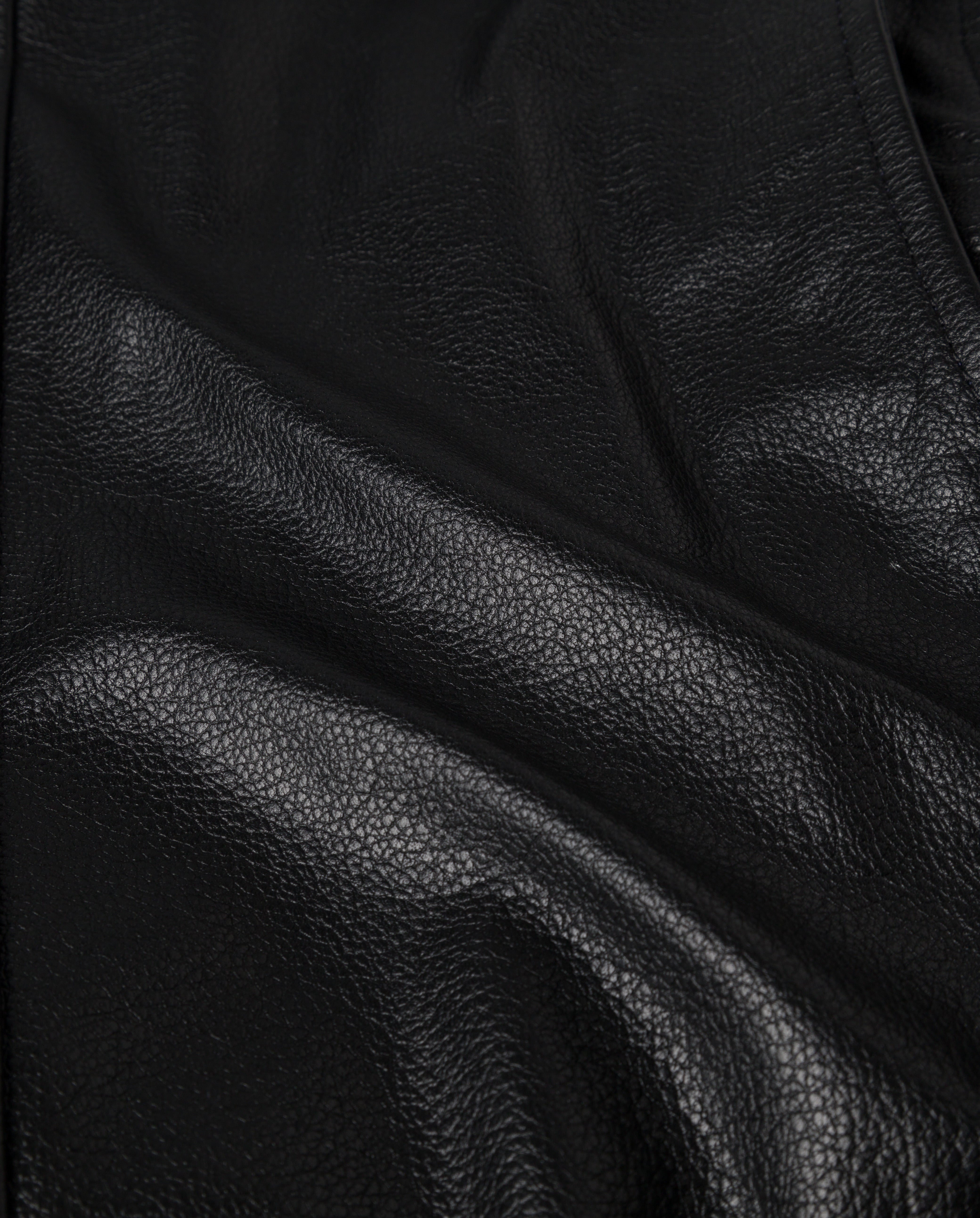 Close-up of the LENNY Jacket by IVY OAK, featuring black textured leather with subtle light reflections and natural creases—ideal for an oversized boyfriend style.