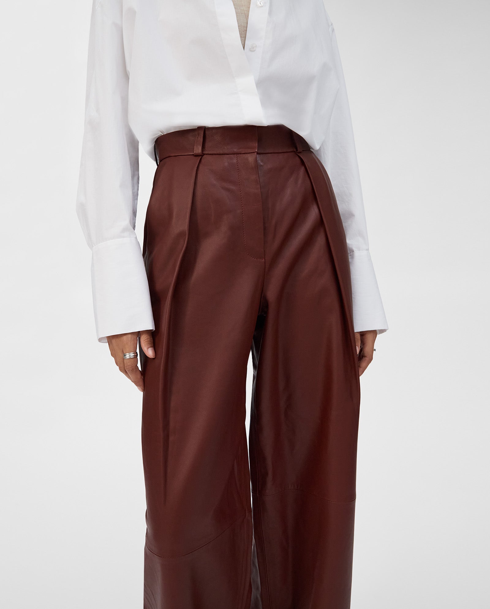 A person wears the IVY OAK LORAINE Trouser paired with a white button-up shirt with wide cuffs, blending modern style and classic cuts.