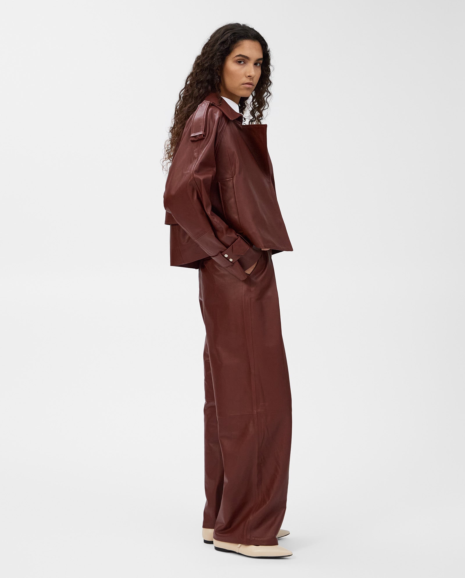 A person with long curly hair wears an IVY OAK LILITH ANN Jacket featuring a large collar and matching pants, standing sideways against a white background.