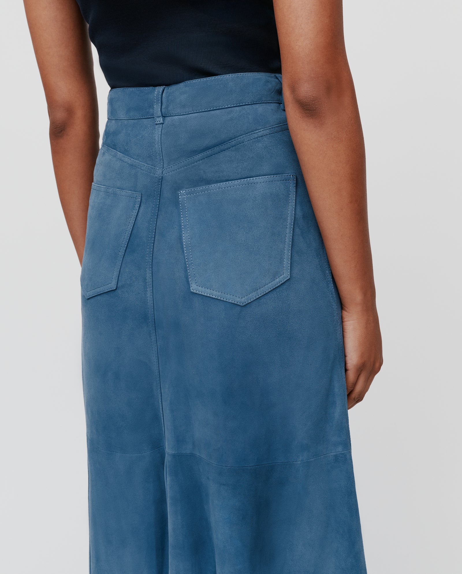 Person shown from the back wears a black top with the IVY OAK LACY Skirt, a high-waist blue skirt featuring visible rear pockets.