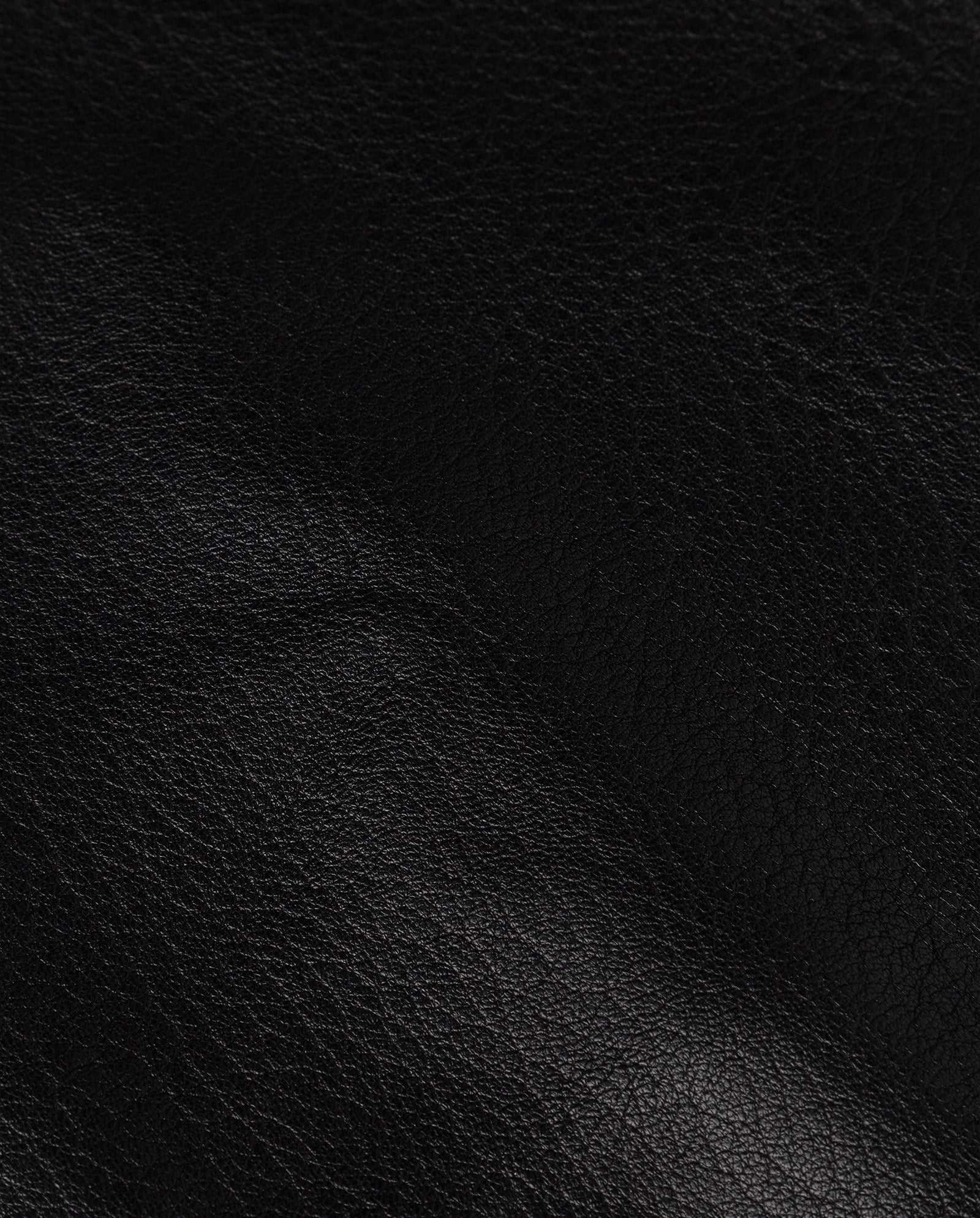 Close-up of the LISANNE Skirt by IVY OAK, featuring textured black leather with natural creases and fine grain patterns, highlighting its premium quality.