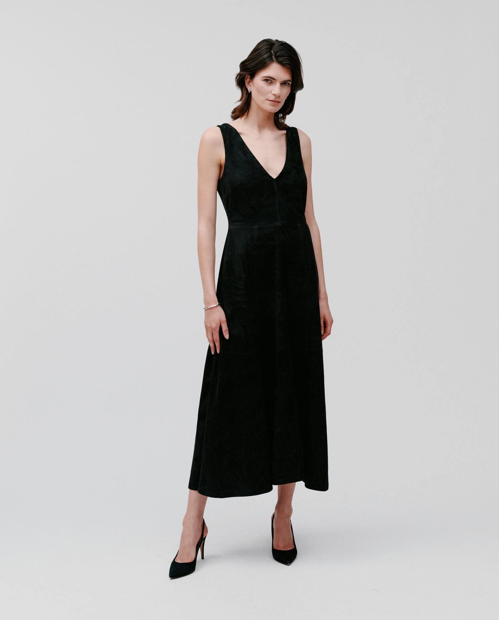 A woman wears the IVY OAK LORENA DRESS in black, featuring a deep V-neckline.