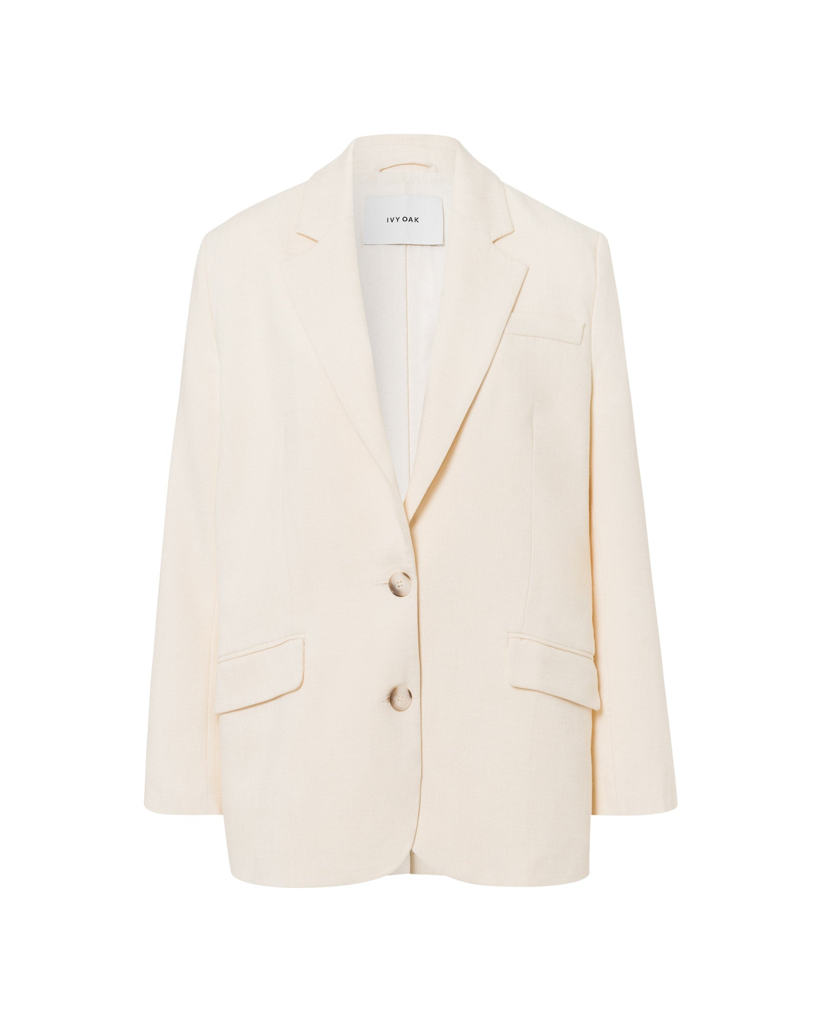 The IVY OAK JUNA Blazer is an oversized, cream-colored women’s blazer featuring two buttons, notched lapels, and flap pockets, shown on a white background.