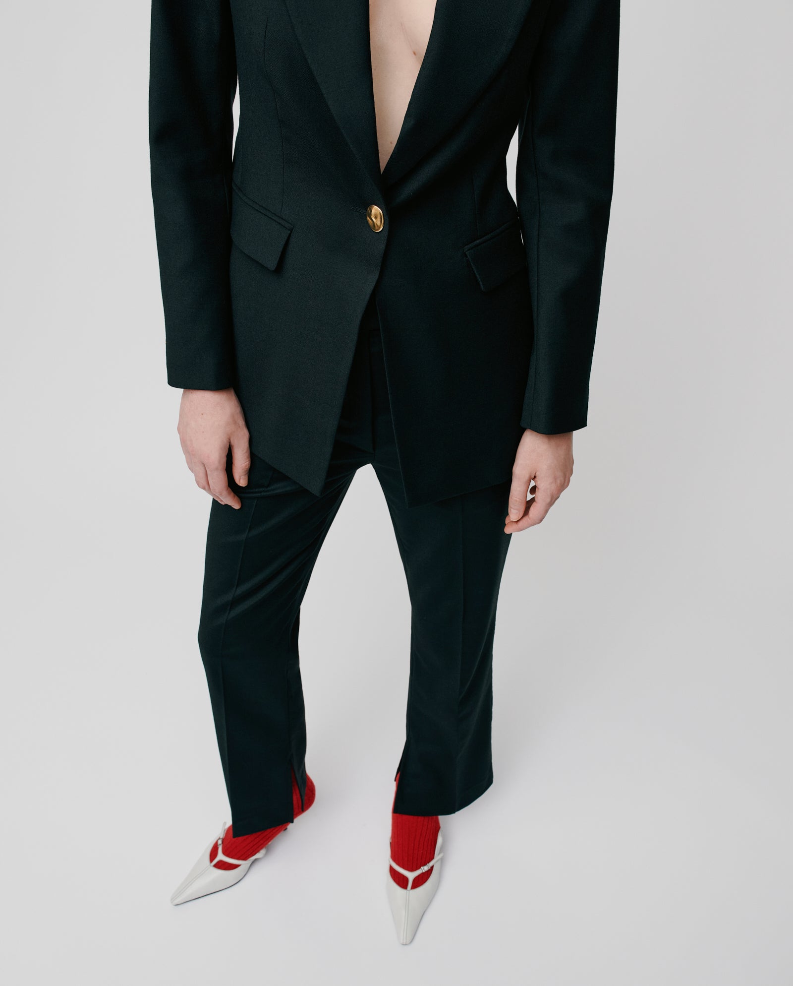 A person wears the IVY OAK JOLANKA Blazer with golden buttons and matching trousers, styled with red socks and white pointed shoes against a plain background.