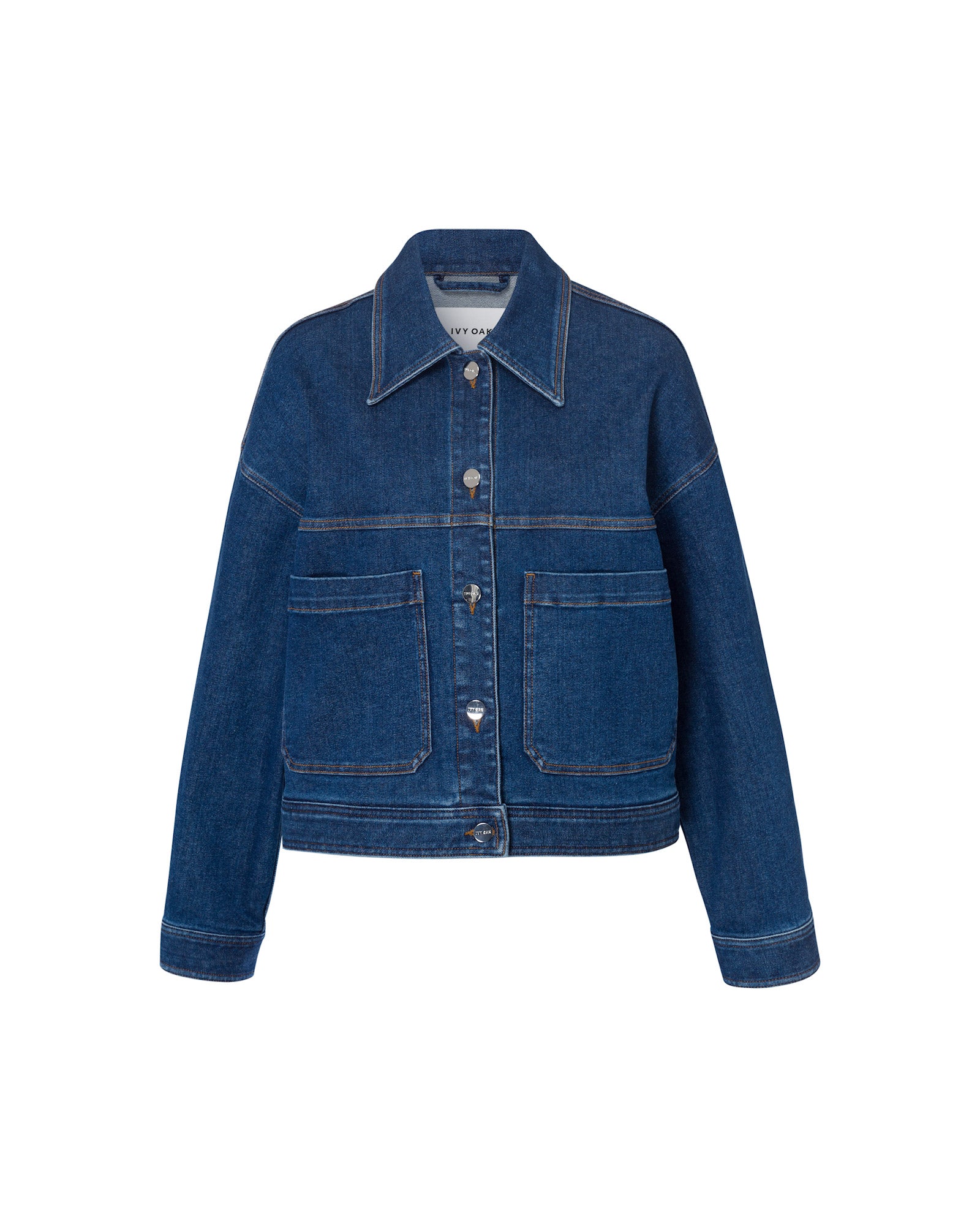The IVY OAK JUPITER Jacket is a blue cropped denim style with large front pockets and button closure, crafted from rich indigo dye and shown on a plain white background.