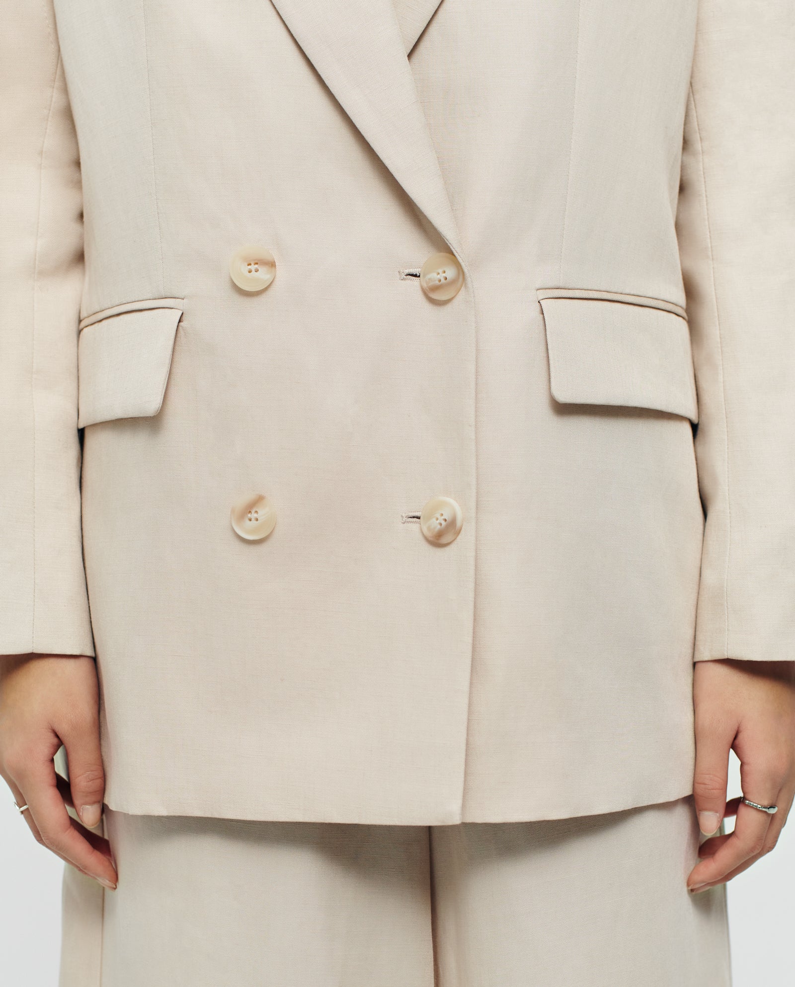 Person wearing the IVY OAK JULIETTE MARIE beige linen-blend double-breasted blazer with matching trousers, hands relaxed by their sides.