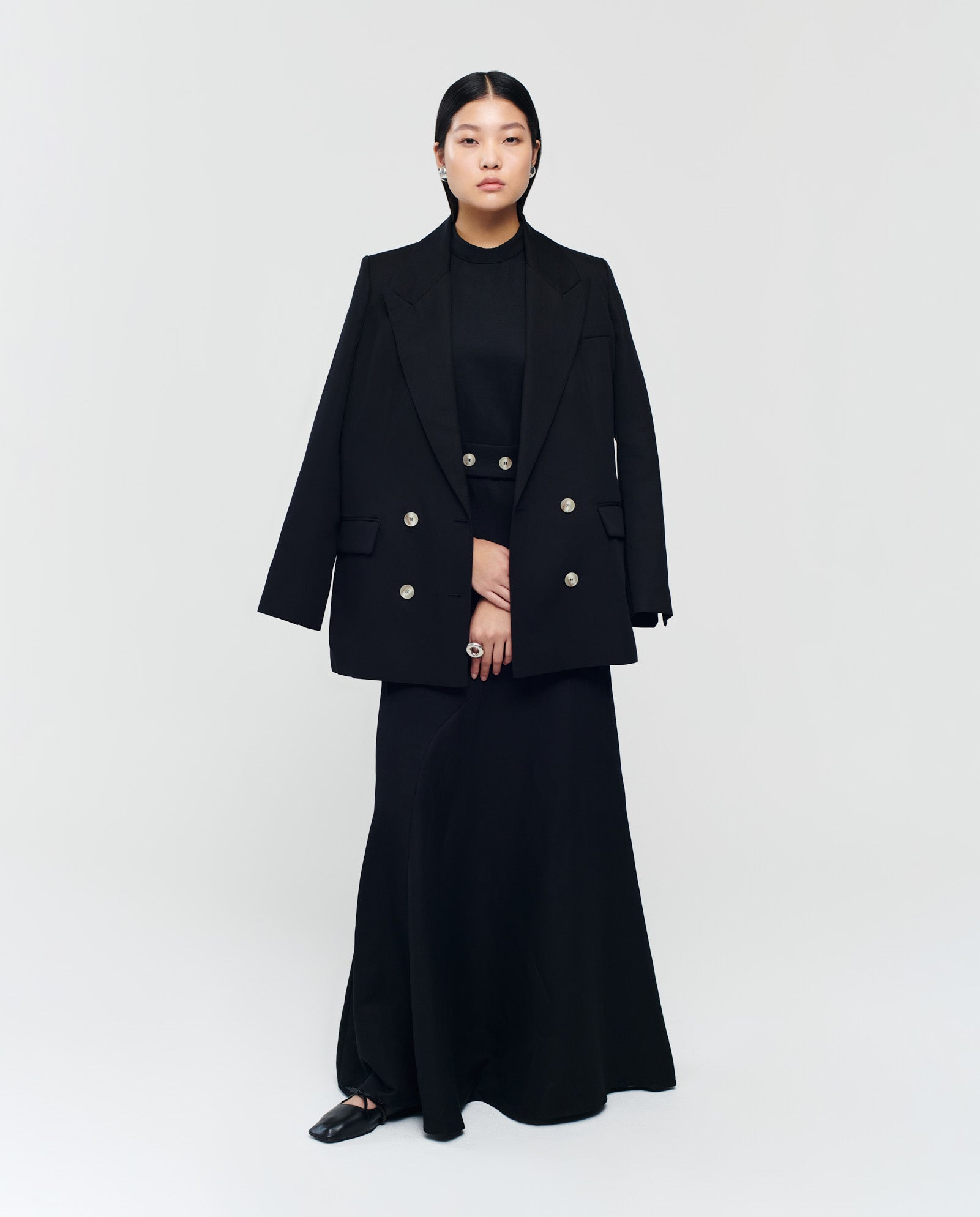 Woman wearing the IVY OAK JULIETTE MARIE Blazer and a long black dress, standing against a plain white background.