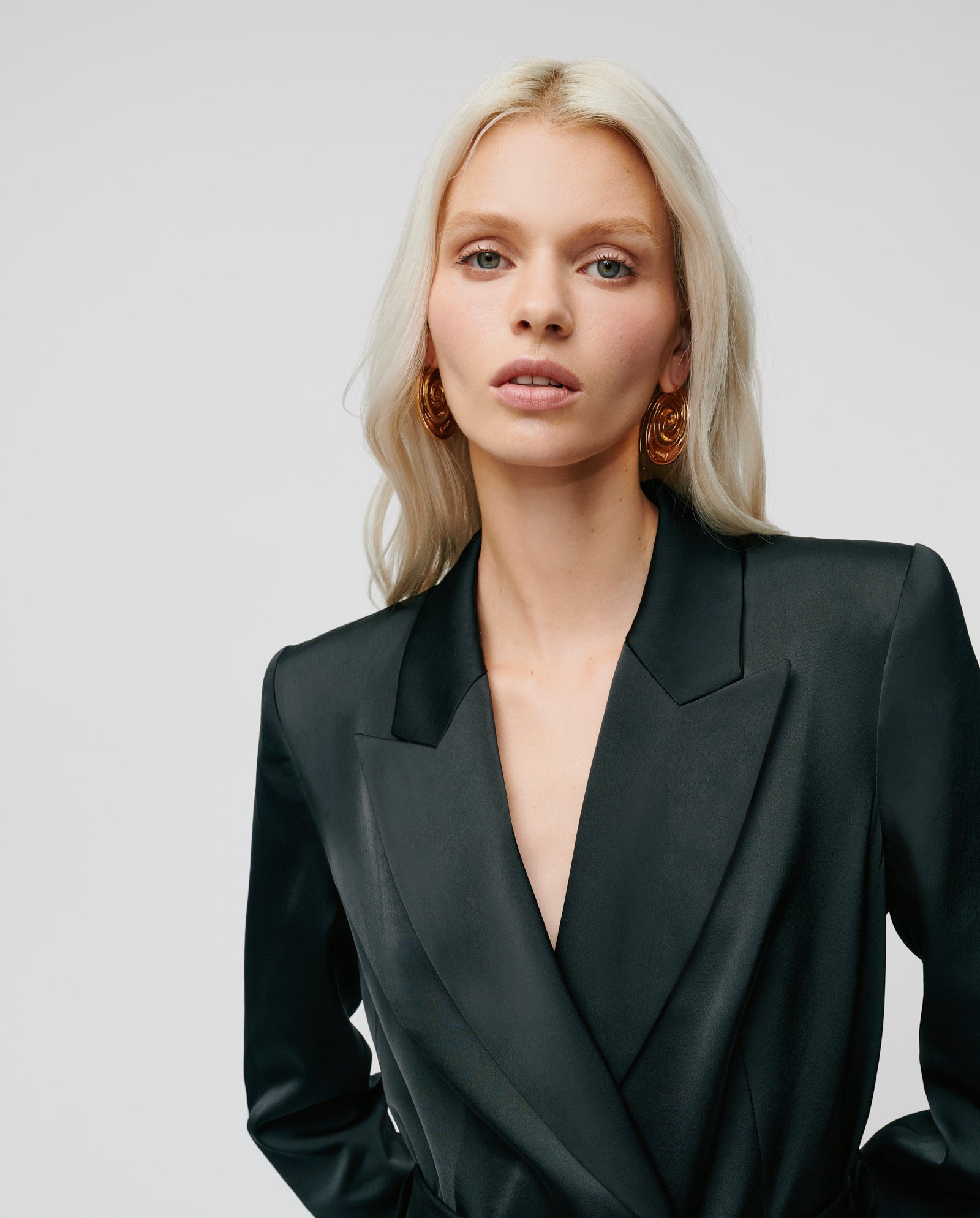 A woman with long blonde hair wears the IVY OAK JOSEPHINA Blazer and gold earrings, posing against a plain background.