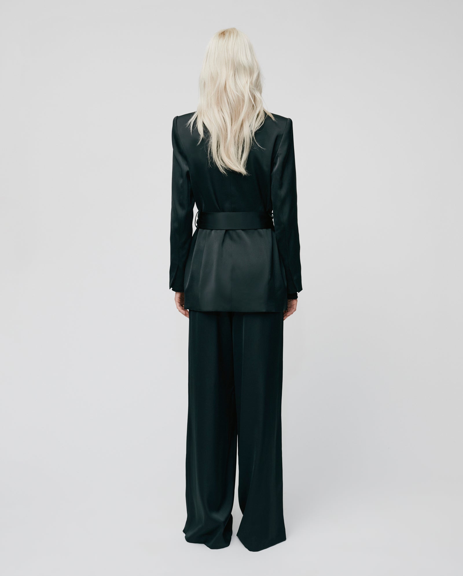 Person with long blond hair wearing a double-breasted IVY OAK JOSEPHINA Blazer and PRIYA ANN trousers, standing with their back to the camera against a plain background.