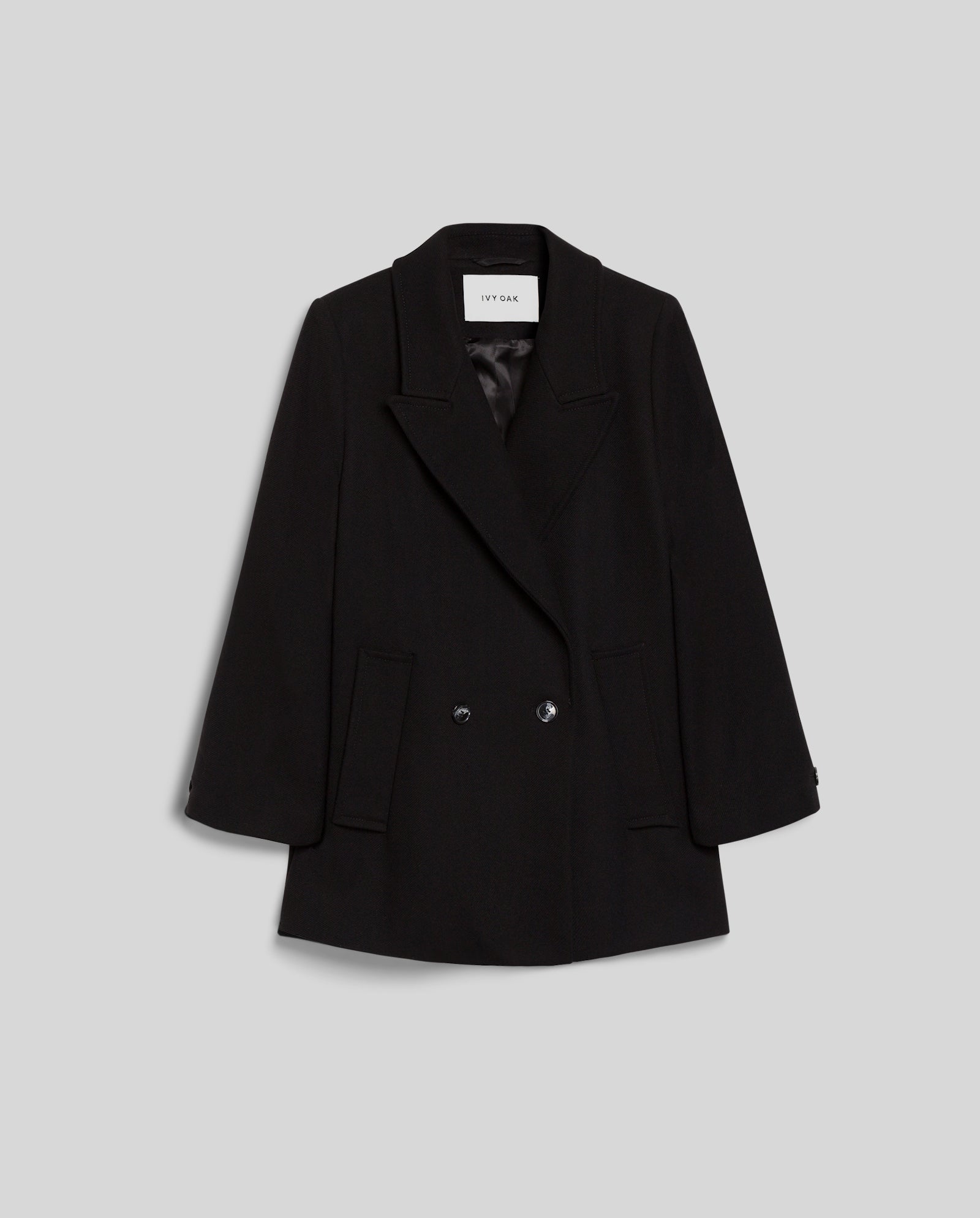 The IVY OAK JENNA Jacket is a black oversized winter blazer with lapels in a double-breasted style, shown against a plain gray background.