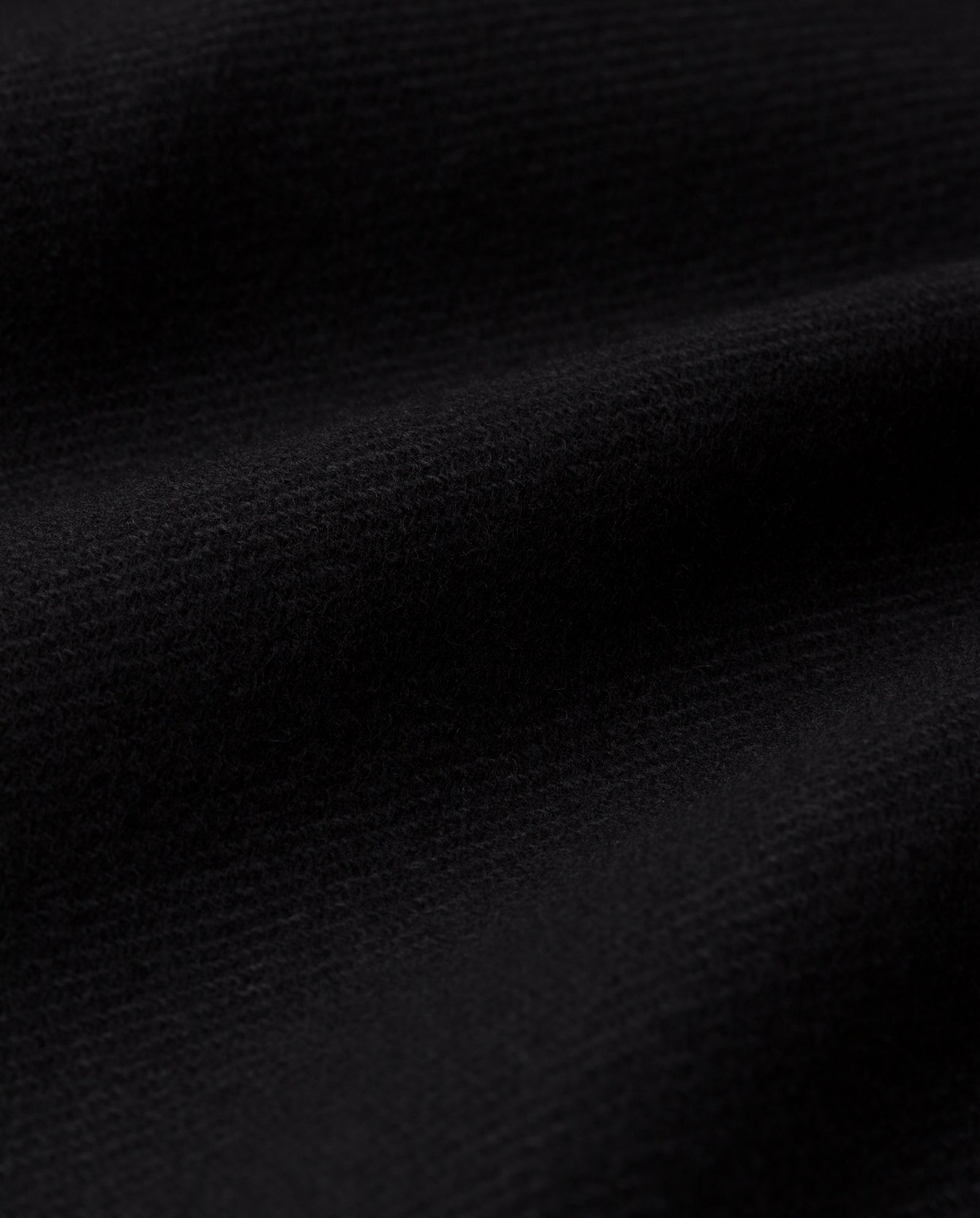 Close-up of the JANET Jacket by IVY OAK, featuring soft black cashmere blend fabric with gentle folds and a textured surface.