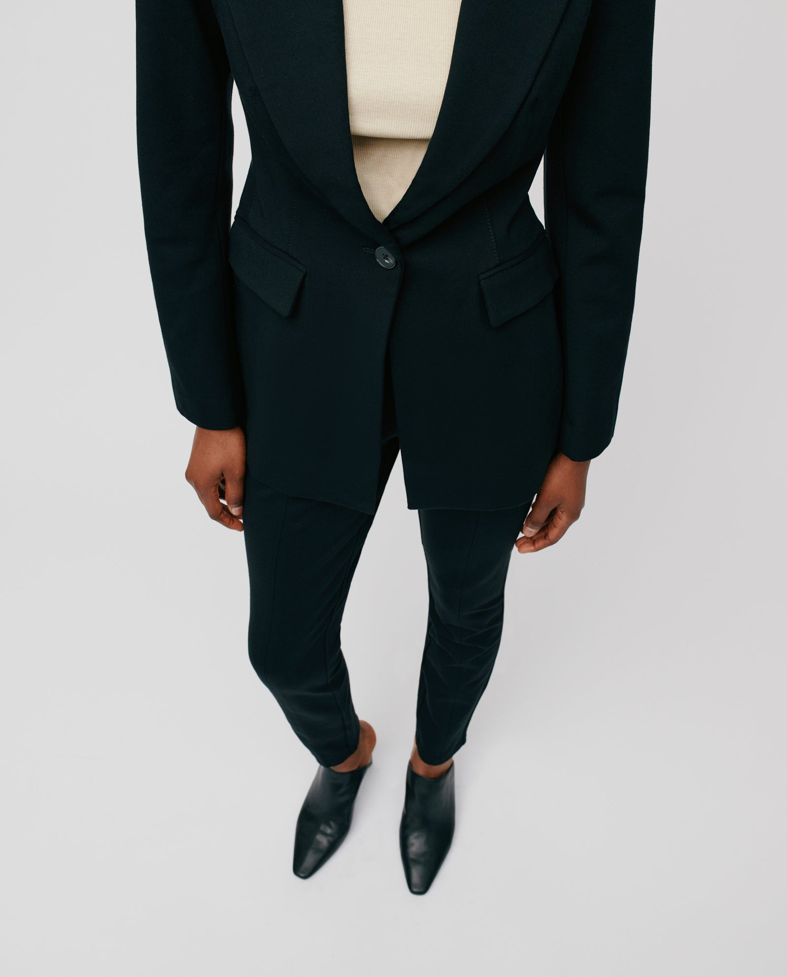 Person in a black suit and black shoes stands with hands by their sides, highlighting the elegant silhouette and detailed topstitching of the IVY OAK JOLANKA KIM Blazer.
