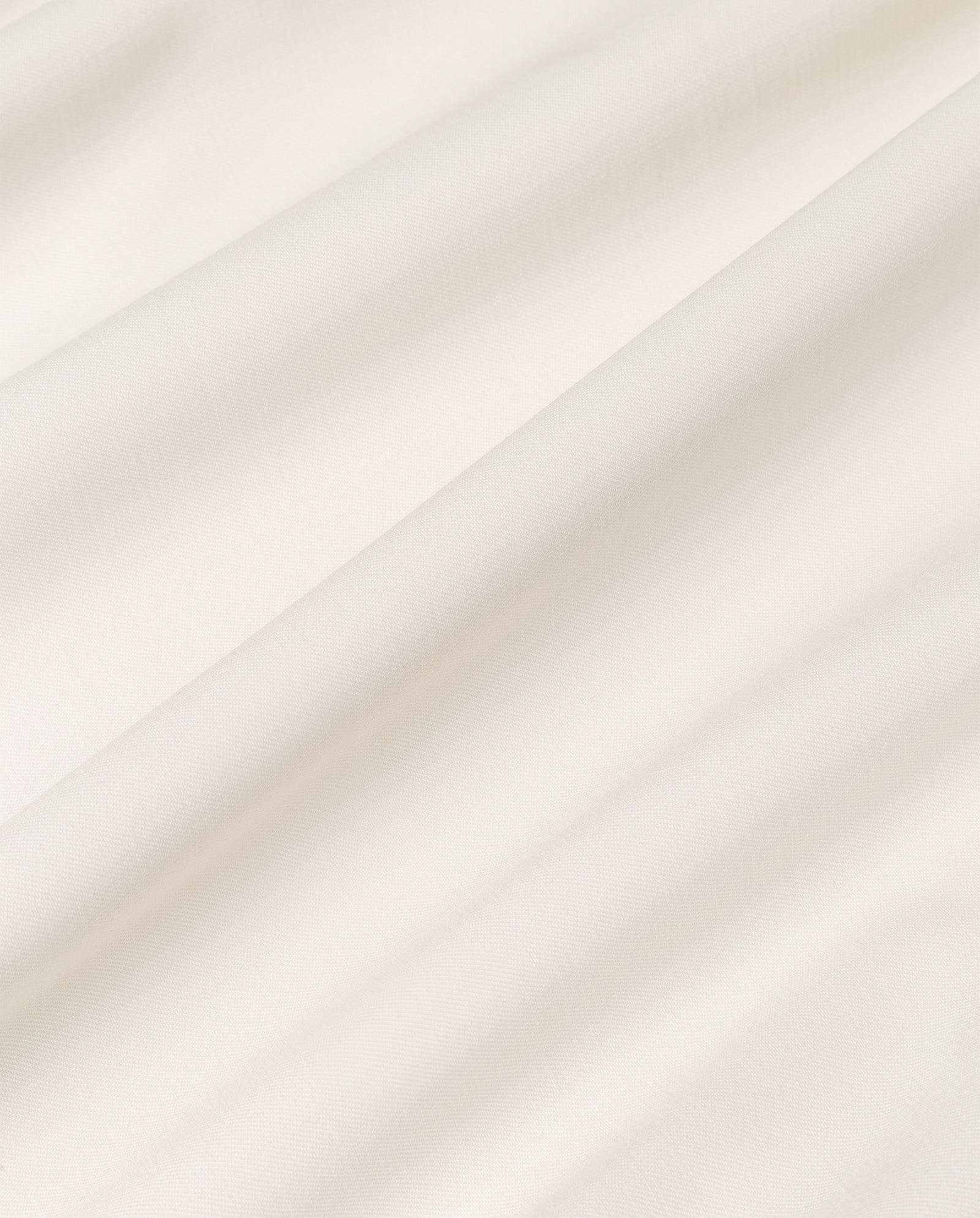 Close-up of smooth, white fabric with soft folds and gentle shadows, perfect for the JANA MIA Blazer by IVY OAK.