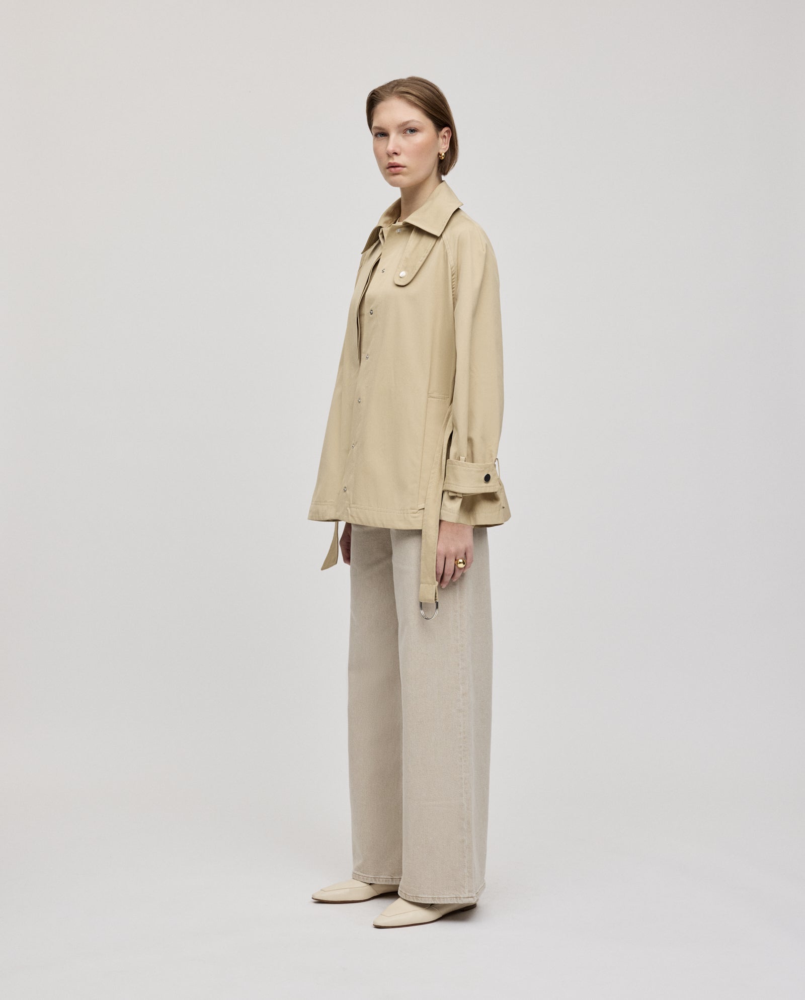 A woman in a beige long-sleeve shirt and wide-leg pants, styled with the IVY OAK JULES Jacket, stands against a plain white background.