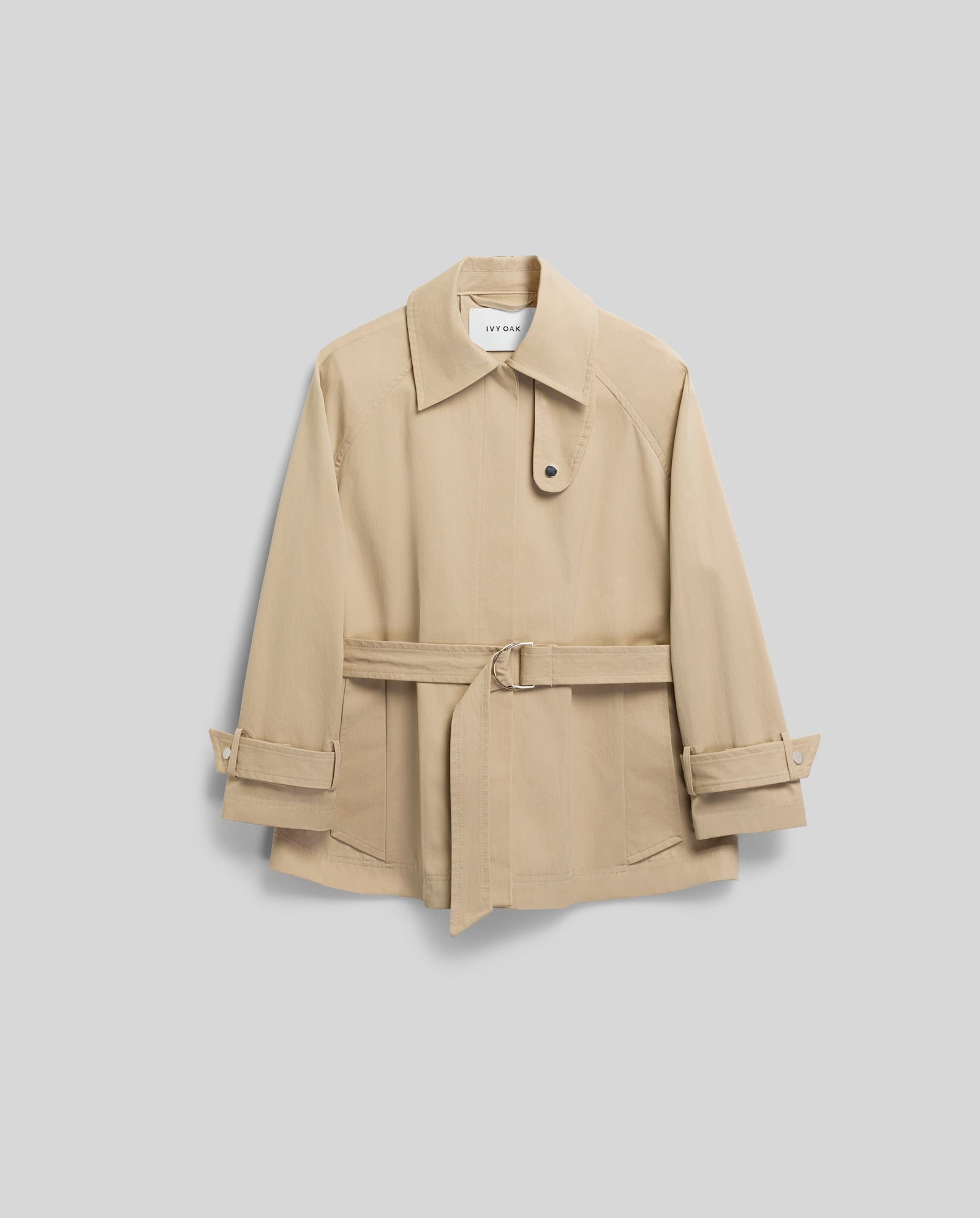 The IVY OAK JULES Jacket in beige features buttoned cuffs, a collar, and an A-line silhouette, displayed against a light gray background.