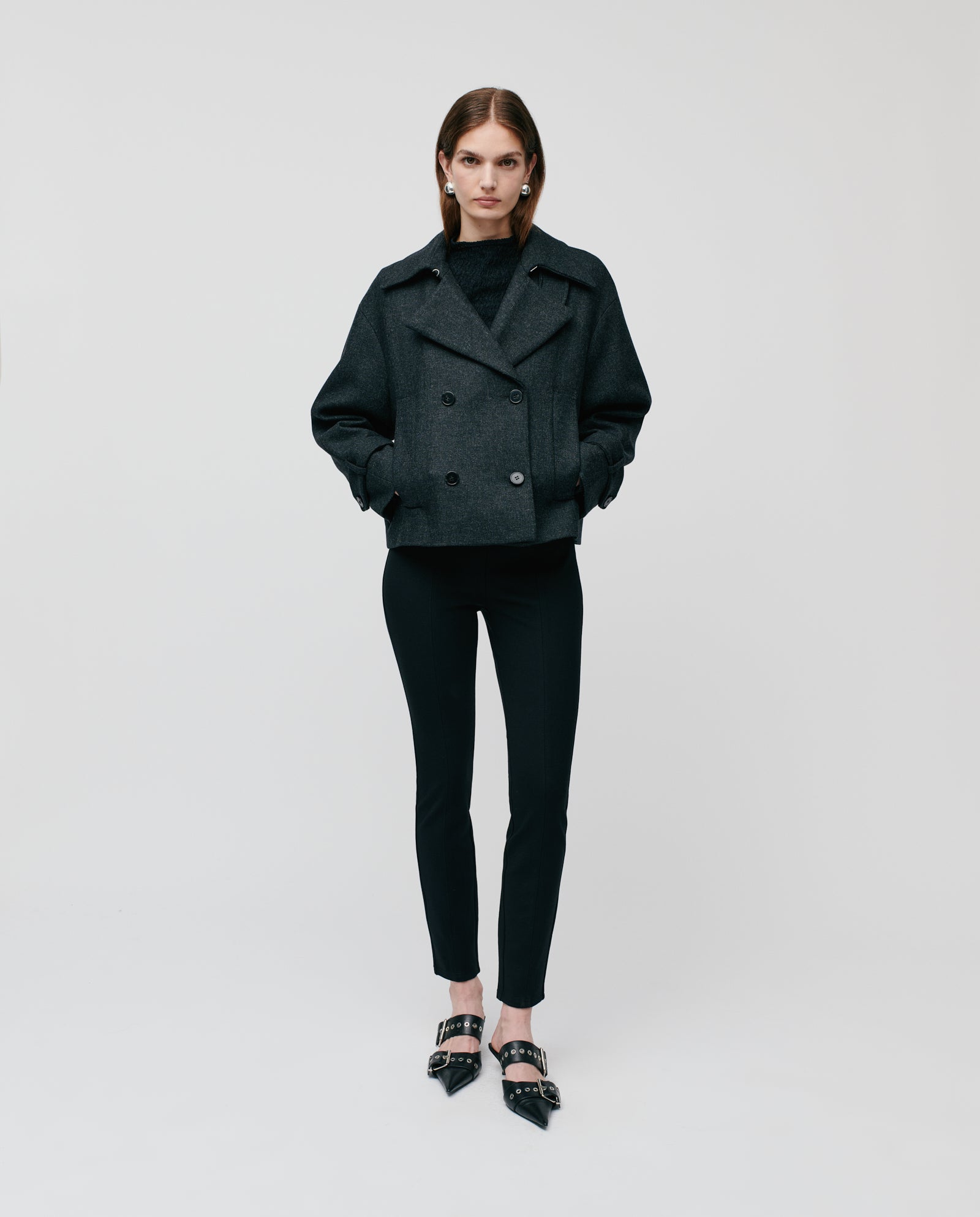 A woman wearing the IVY OAK JANET Wool Blazer, black pants, and black heels stands against a plain white background.