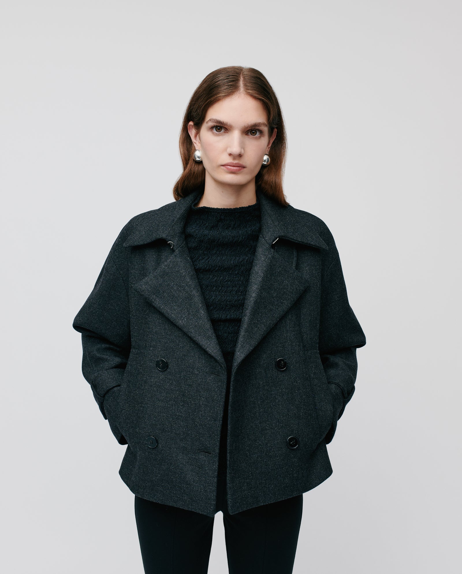 Woman in the IVY OAK JANET Wool Blazer, double-breasted, standing with hands in pockets against a plain light background.