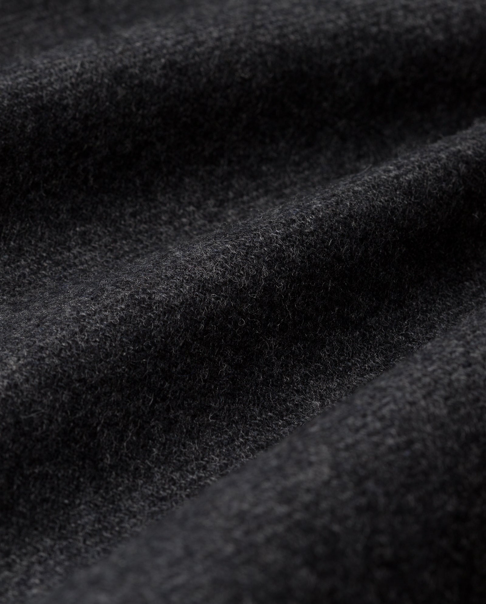 Close-up of soft, dark gray wool fabric with visible texture and folds, perfect for the JANET Wool Blazer by IVY OAK in a premium cashmere and wool blend.