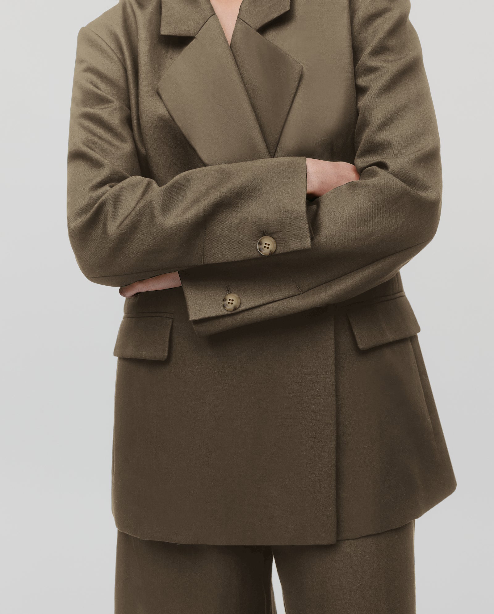 Person wearing the IVY OAK JASEMINA ROSE Blazer in olive green, arms crossed, shown from shoulders to knees against a plain background.