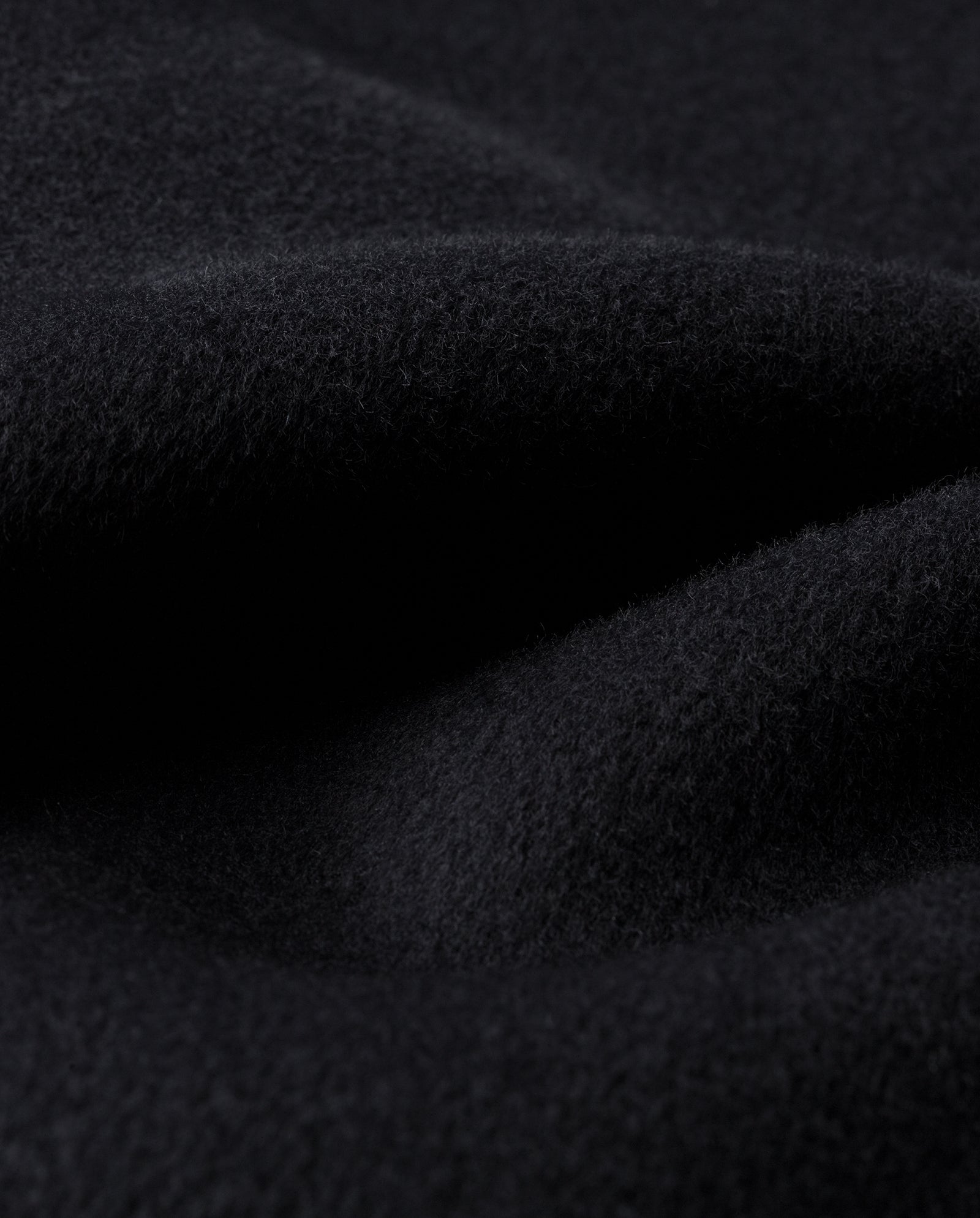 Close-up of soft, dark black fabric with a cozy, fuzzy texture and gentle folds—perfect for the IVY OAK AMY Scarf that’s RWS certified.