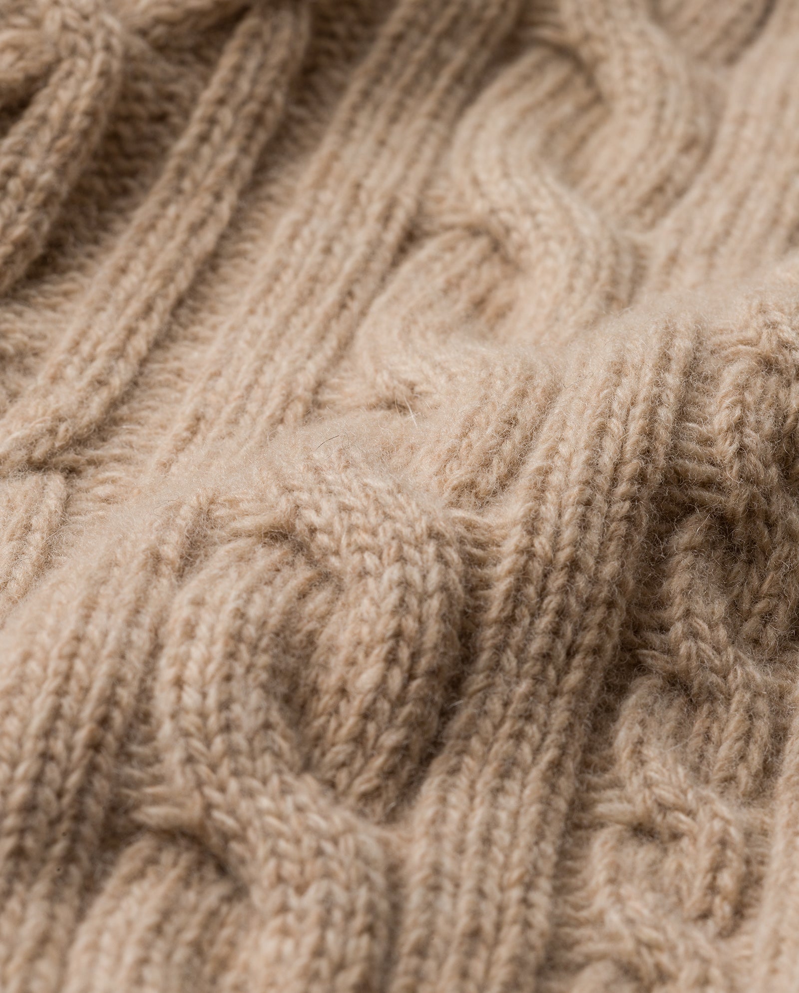 Close-up of the IVY OAK AMELIA Scarf in beige, crafted from supergeelong extrafine merino wool with a soft cable-knit texture—ideal for cozy winter days.