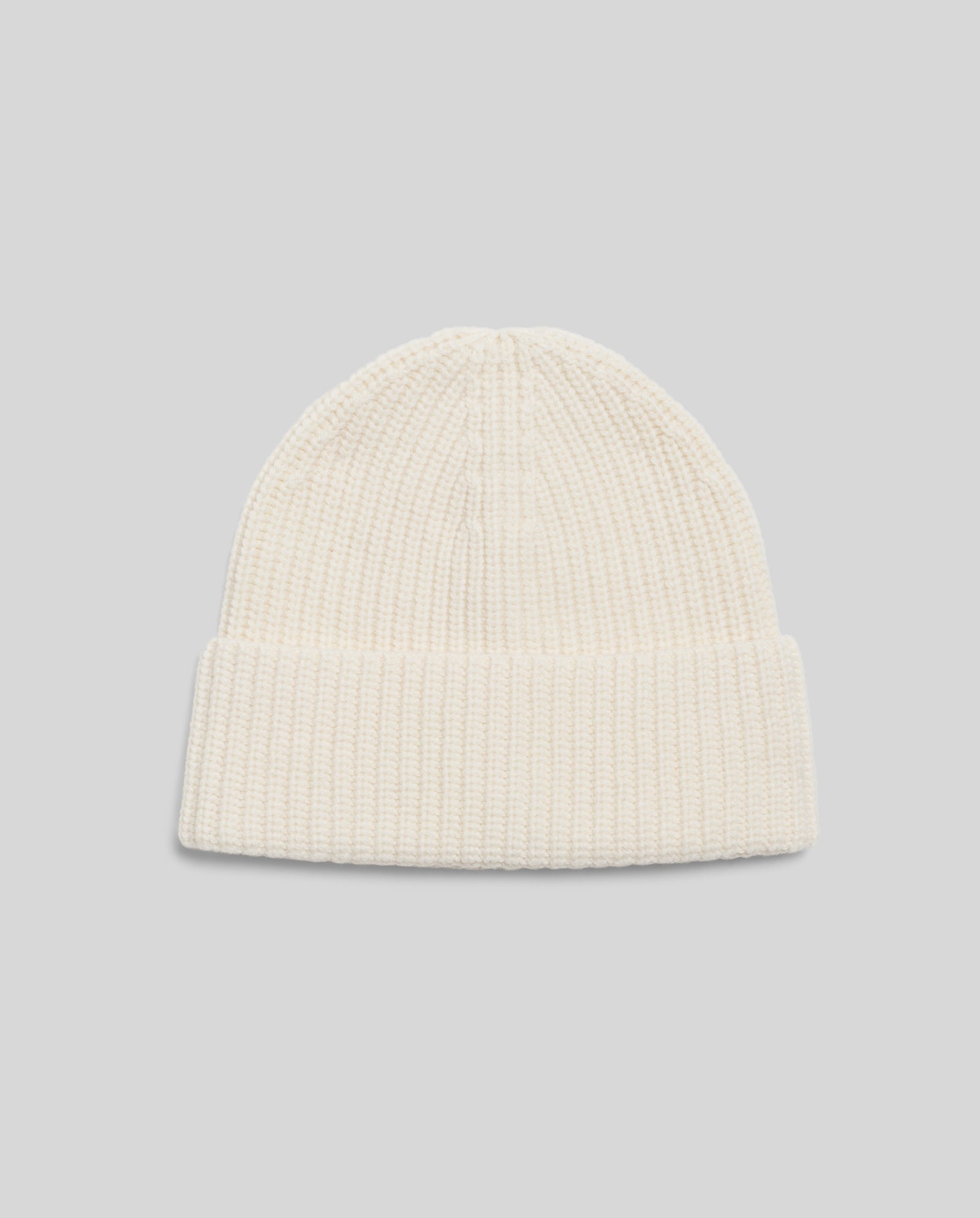 The AMBER Beanie by IVY OAK, in cream ribbed merino wool with a folded brim, is shown on a light gray background.