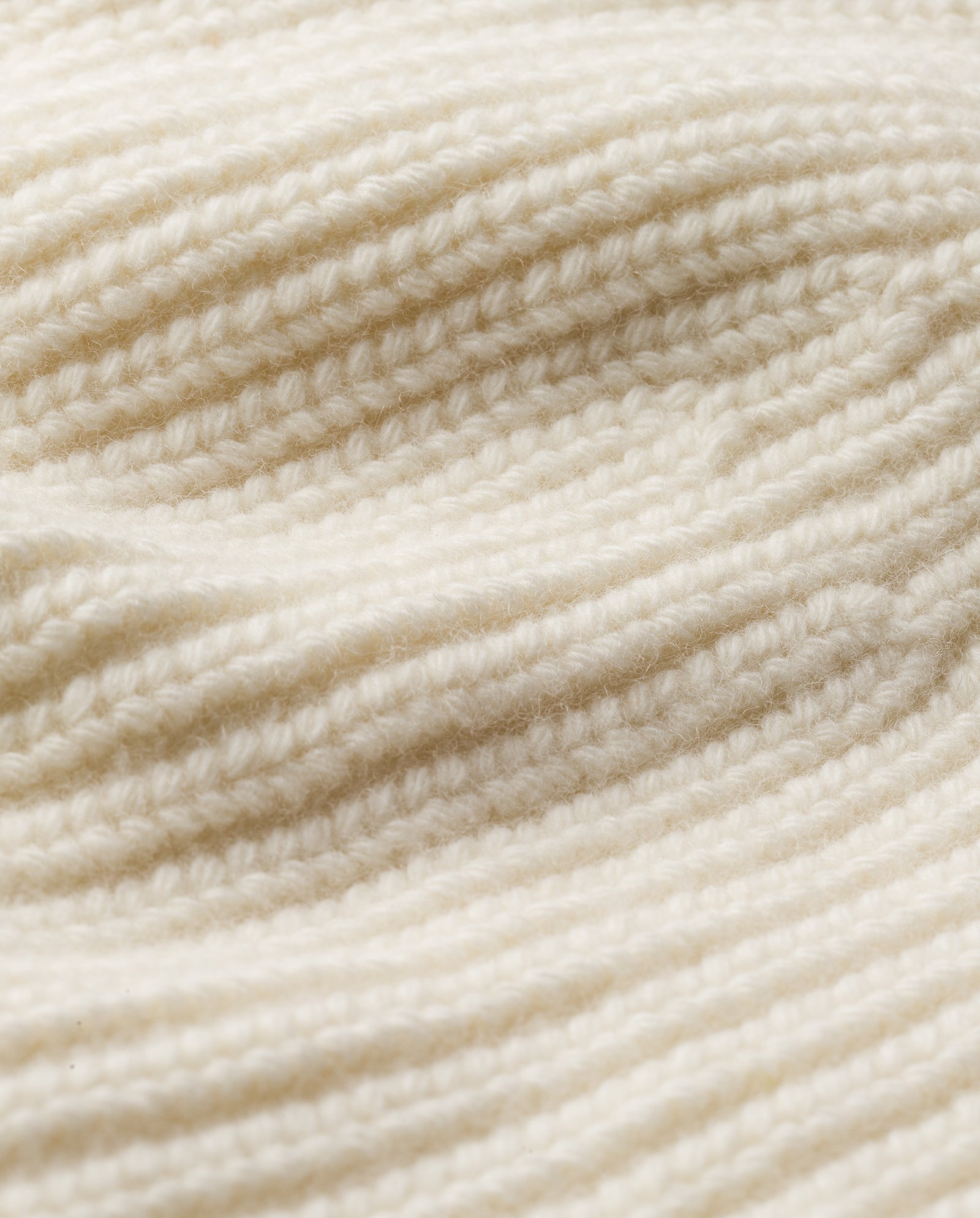 Close-up of the cream-colored ribbed knit on the AMBER Beanie by IVY OAK, crafted from soft merino wool with visible yarn details—ideal for a cozy winter accessory.