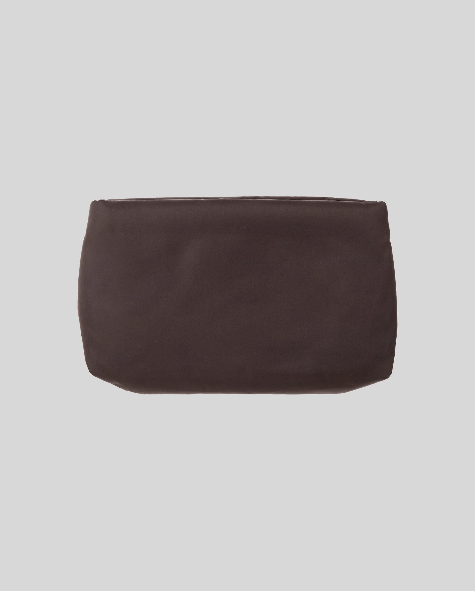 The AMINA ROSE Clutch by IVY OAK, a plain rectangular pouch in dark brown fabric with a metal zip, rests on a light gray background.