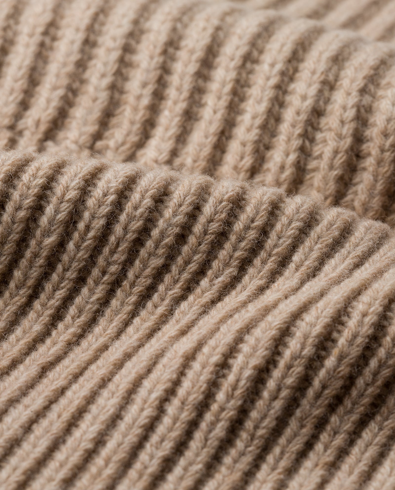 Close-up of the ANNIE LEE Balaclava by IVY OAK, featuring soft beige ribbed knit made from extrafine merino wool and showcasing its vertical pattern.