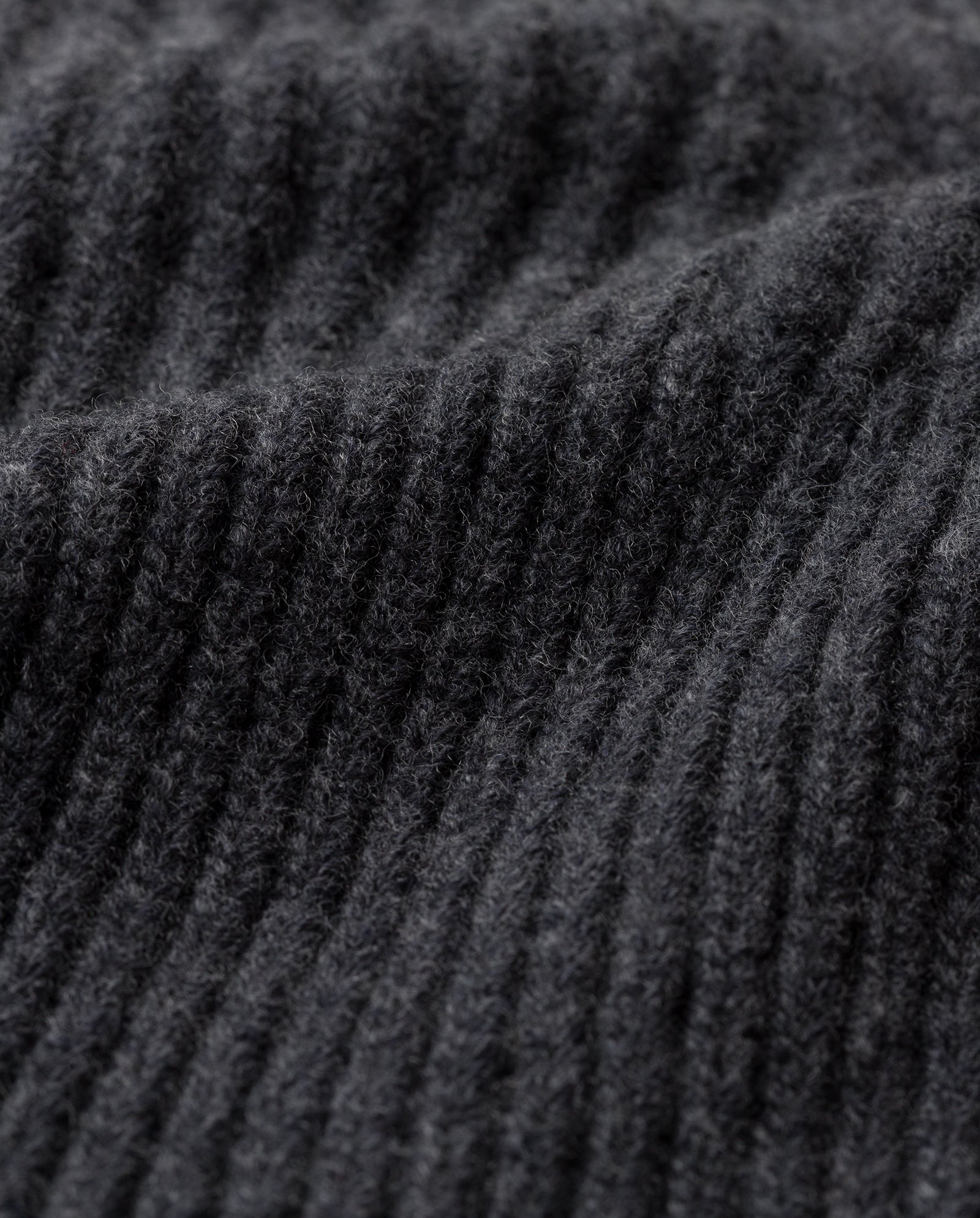 Close-up of dark gray ribbed knit fabric, expertly crafted from extrafine merino wool by IVY OAK for the ANNIE LEE Balaclava—a soft, textured option perfect for cozy comfort.