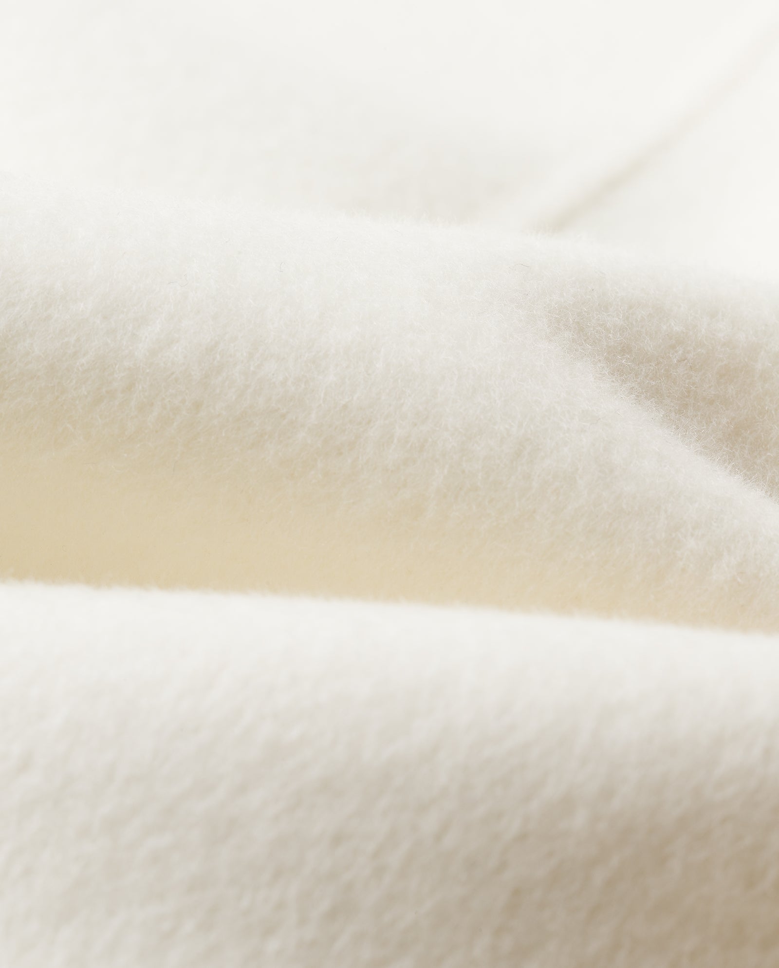 Close-up of the AMY Wool Scarf by IVY OAK, featuring cozy, white, double-face fabric with gentle folds and a smooth, textured surface.