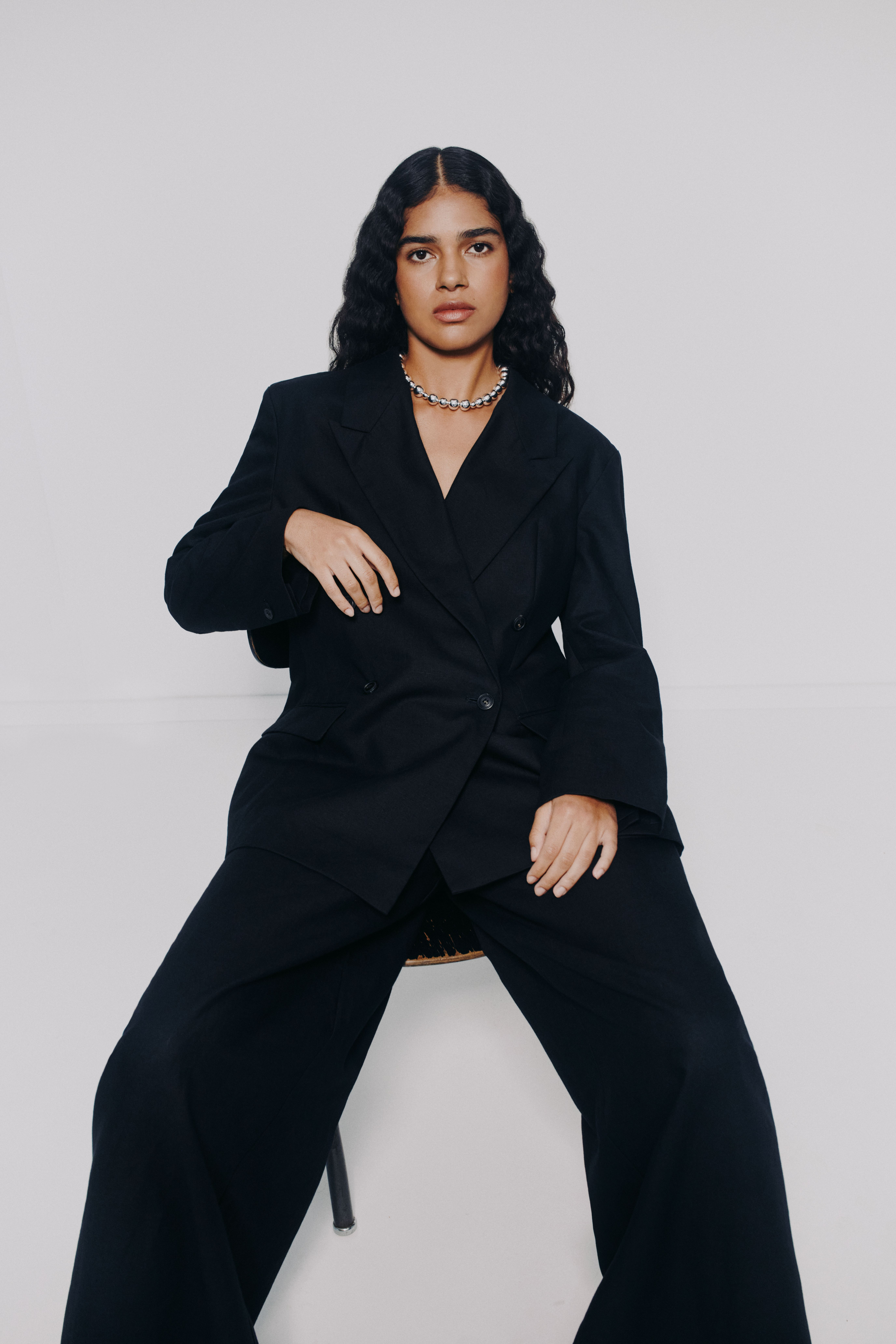 young woman in a business suit comfortably sitting on a chair