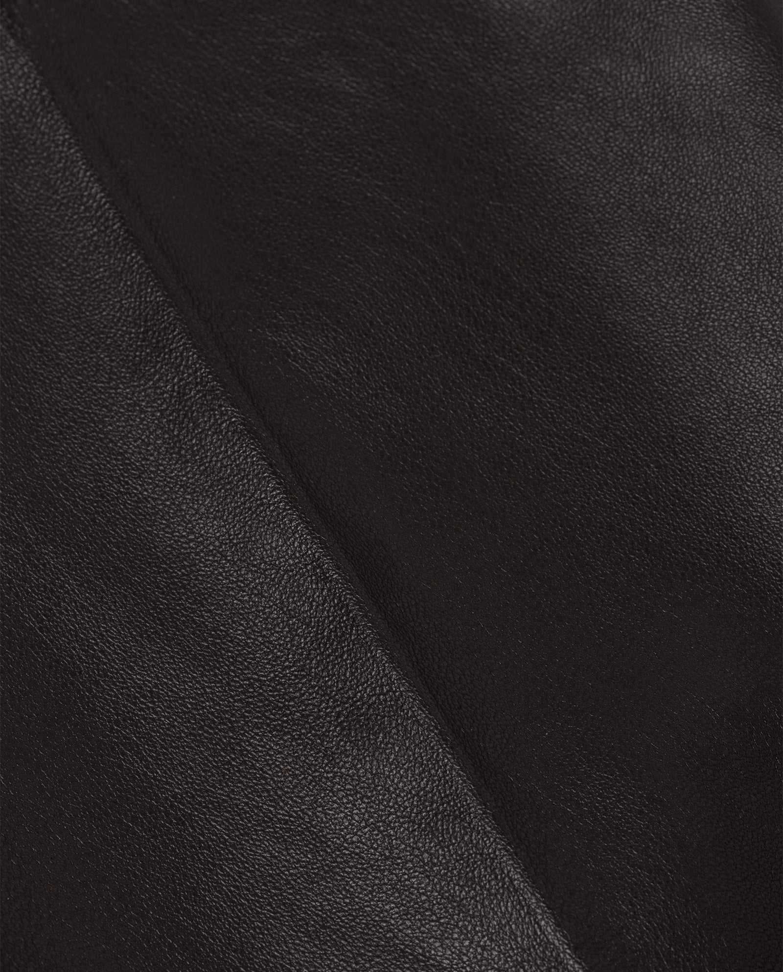 Close-up of the smooth, dark brown chrome-free leather texture and diagonal seam on the IVY OAK LAURA Leather Trousers.