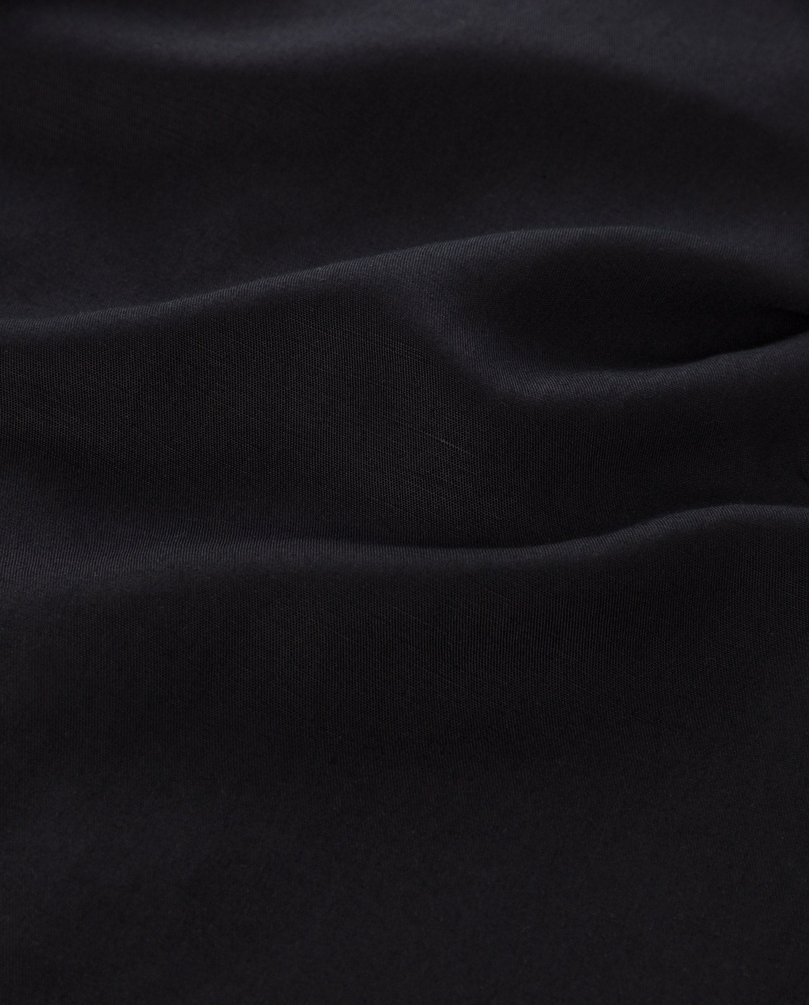 Close-up of smooth, dark linen blend fabric with gentle folds and soft shadows—perfect for the elegant TAILOR SUE Top by IVY OAK.