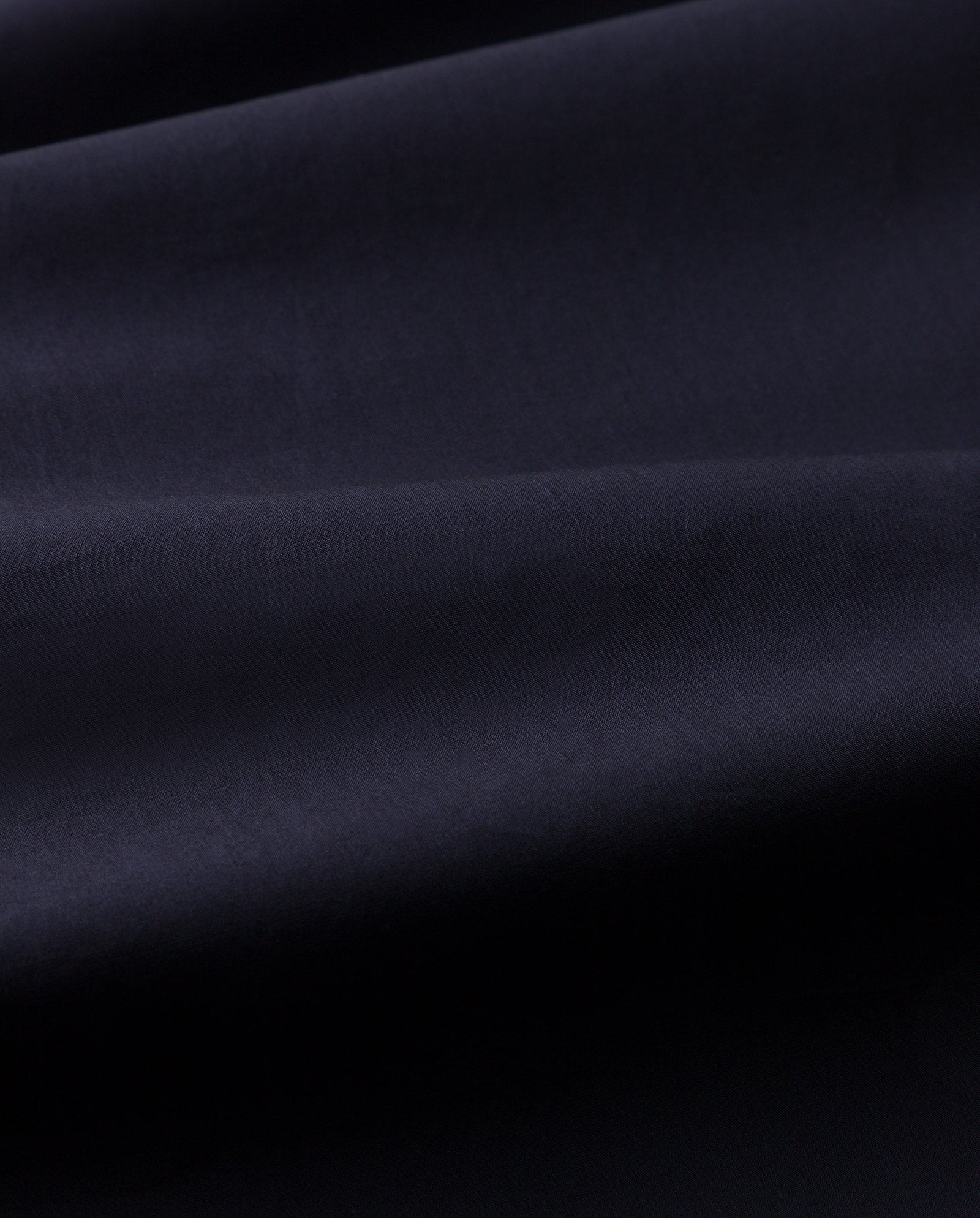 Close-up of smooth, dark navy blue fabric with gentle folds and a soft texture from the ELVIRA Shirt by IVY OAK—ideal for a chic, stylish look.