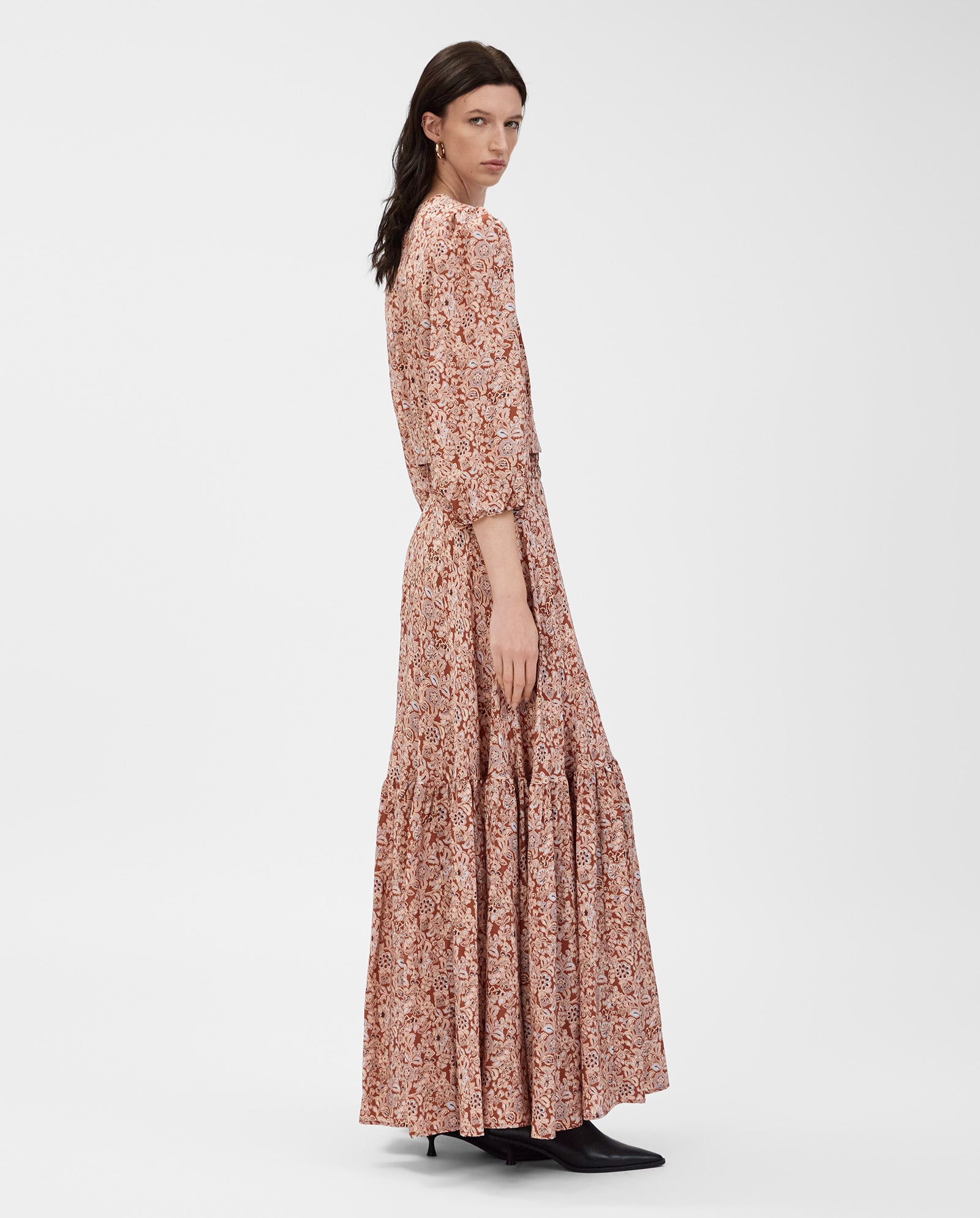 A woman wearing the IVY OAK ENRICA Blouse stands sideways against a plain white background, pairing it with black boots.