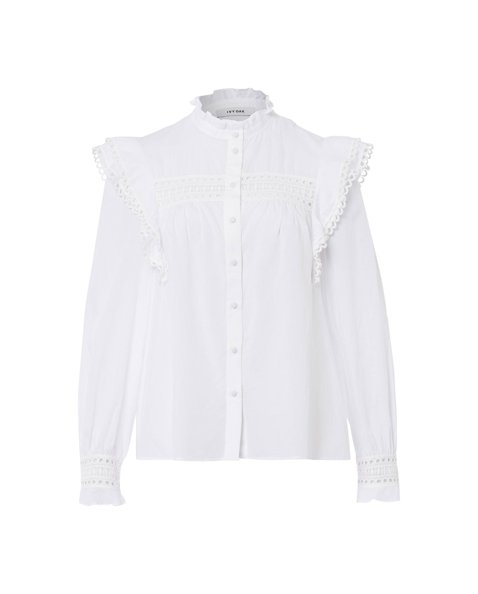 The IVY OAK EVELINA Blouse is a white, long-sleeve cotton voile top featuring ruffles, lace tape on shoulders and cuffs, and front buttons.