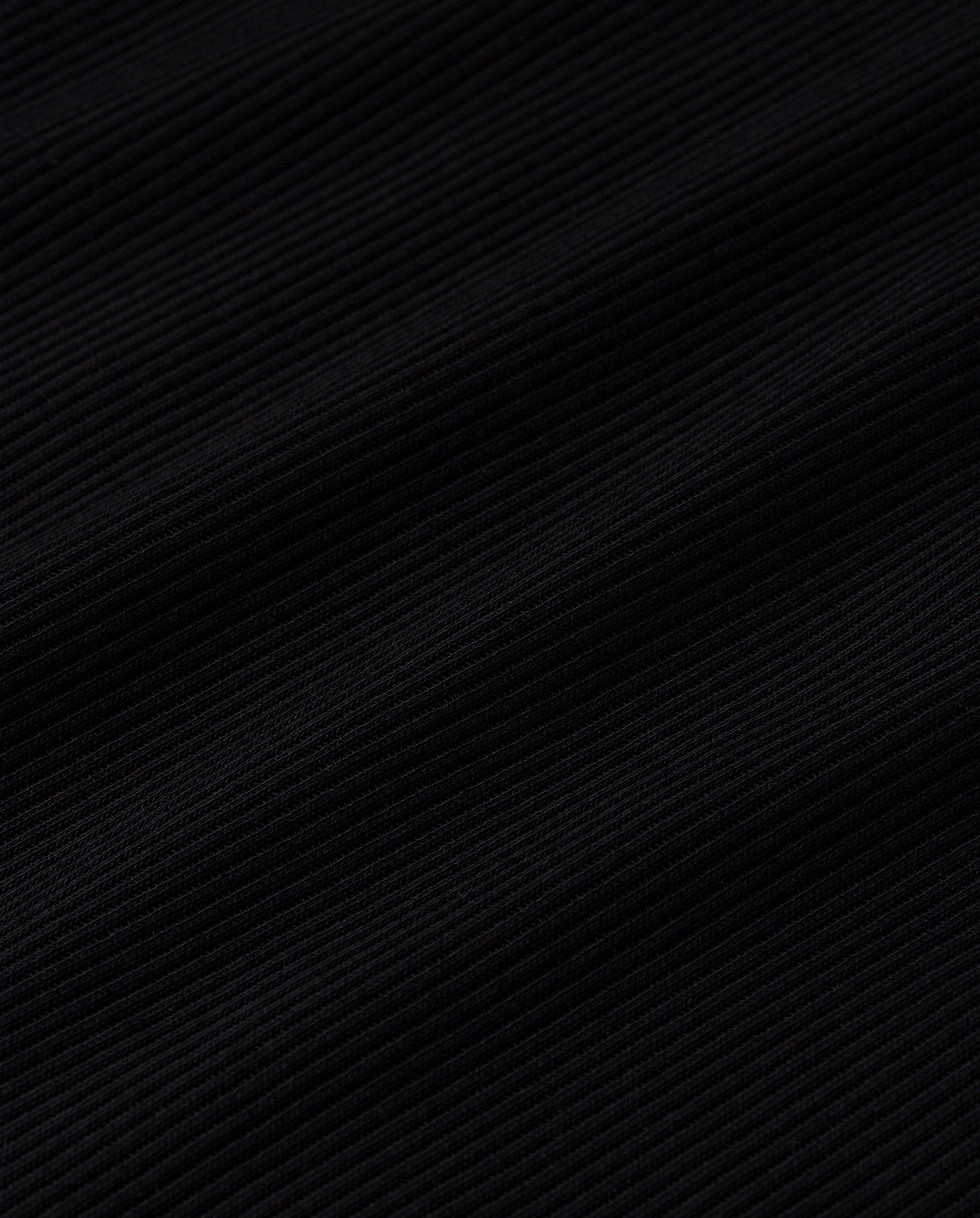 Close-up of the black ribbed fabric on the IVY OAK KRISTIN Rib T-Shirt, highlighting diagonal textured lines and the soft organic cotton feel typical of fitted jersey garments.