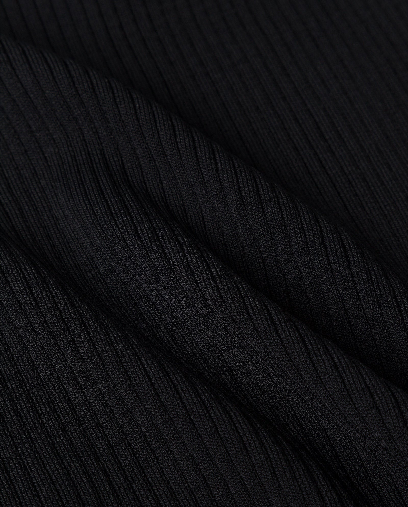 Close-up of the black rib structure with diagonal textured lines and soft folds on the IVY OAK KLAUDIA Dress.