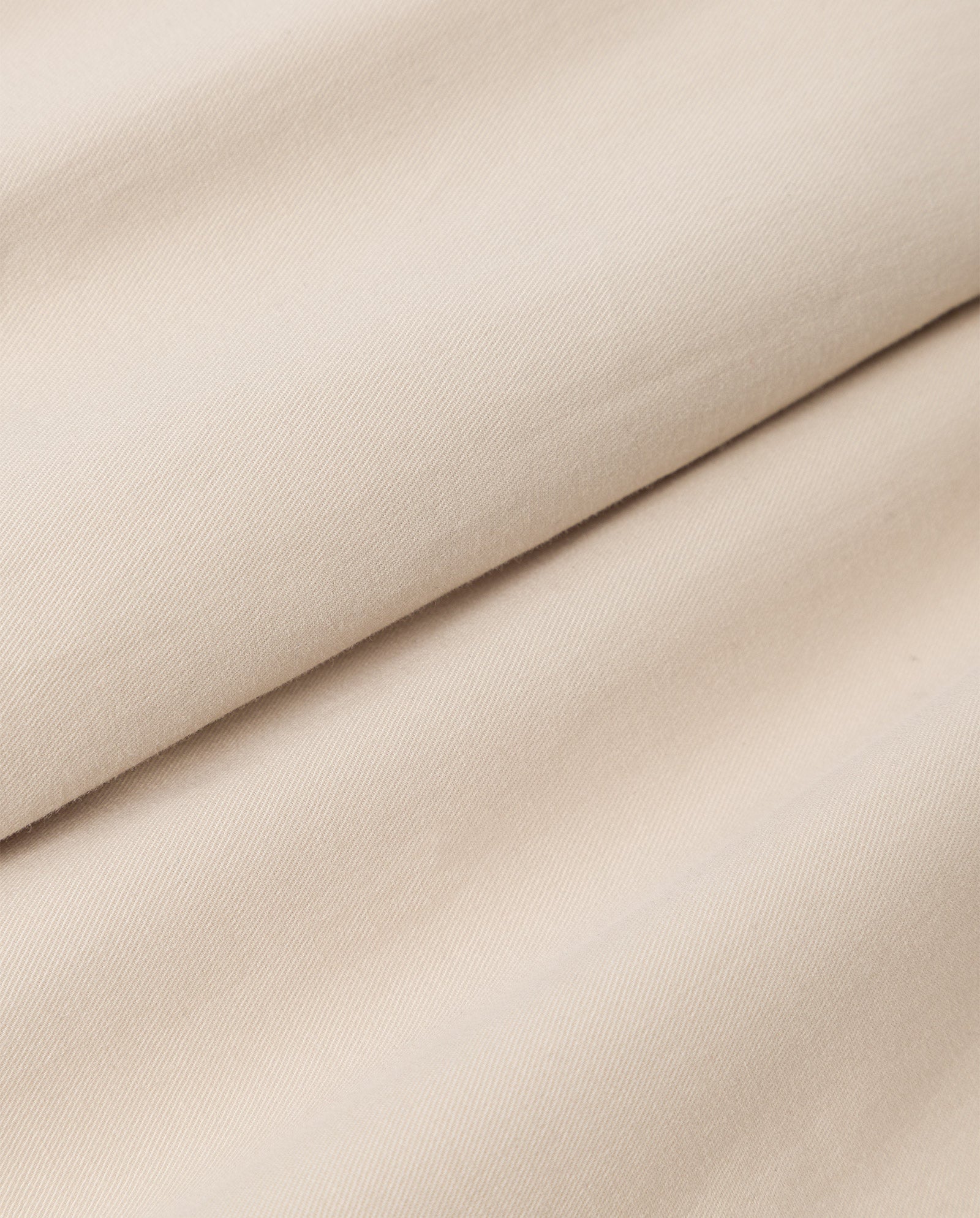 Close-up of the PERSEPHONE Trousers by IVY OAK, made from light beige organic cotton fabric with a smooth, slightly textured surface.