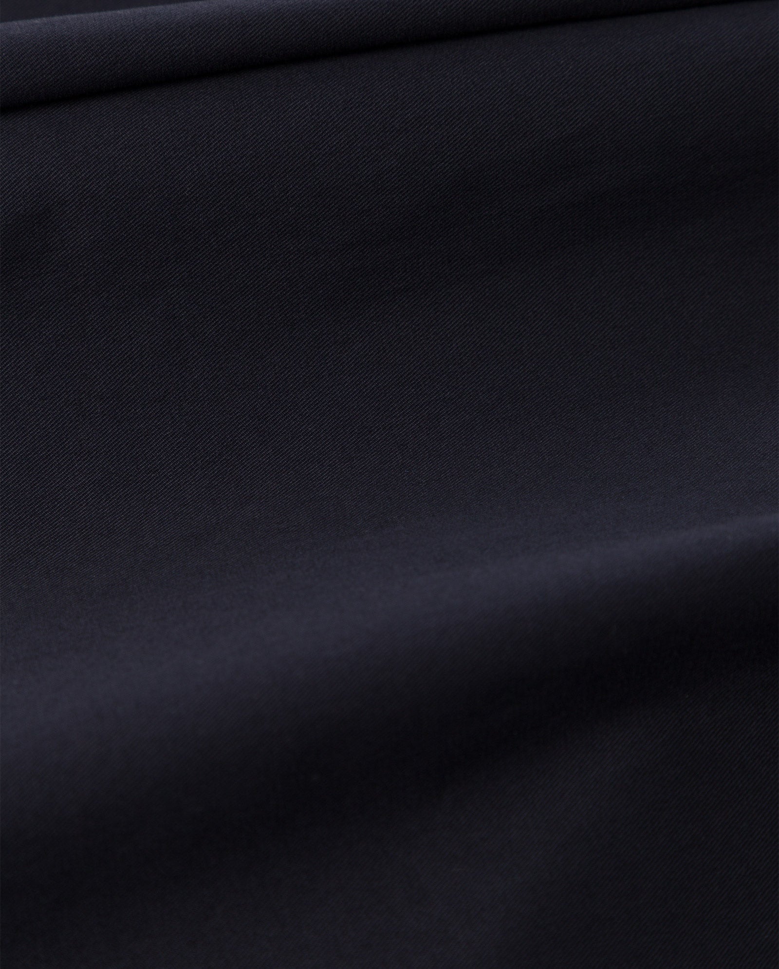 Close-up of smooth, dark navy blue organic cotton fabric with subtle folds and a soft, matte texture on the IVY OAK PERSEPHONE Trousers.