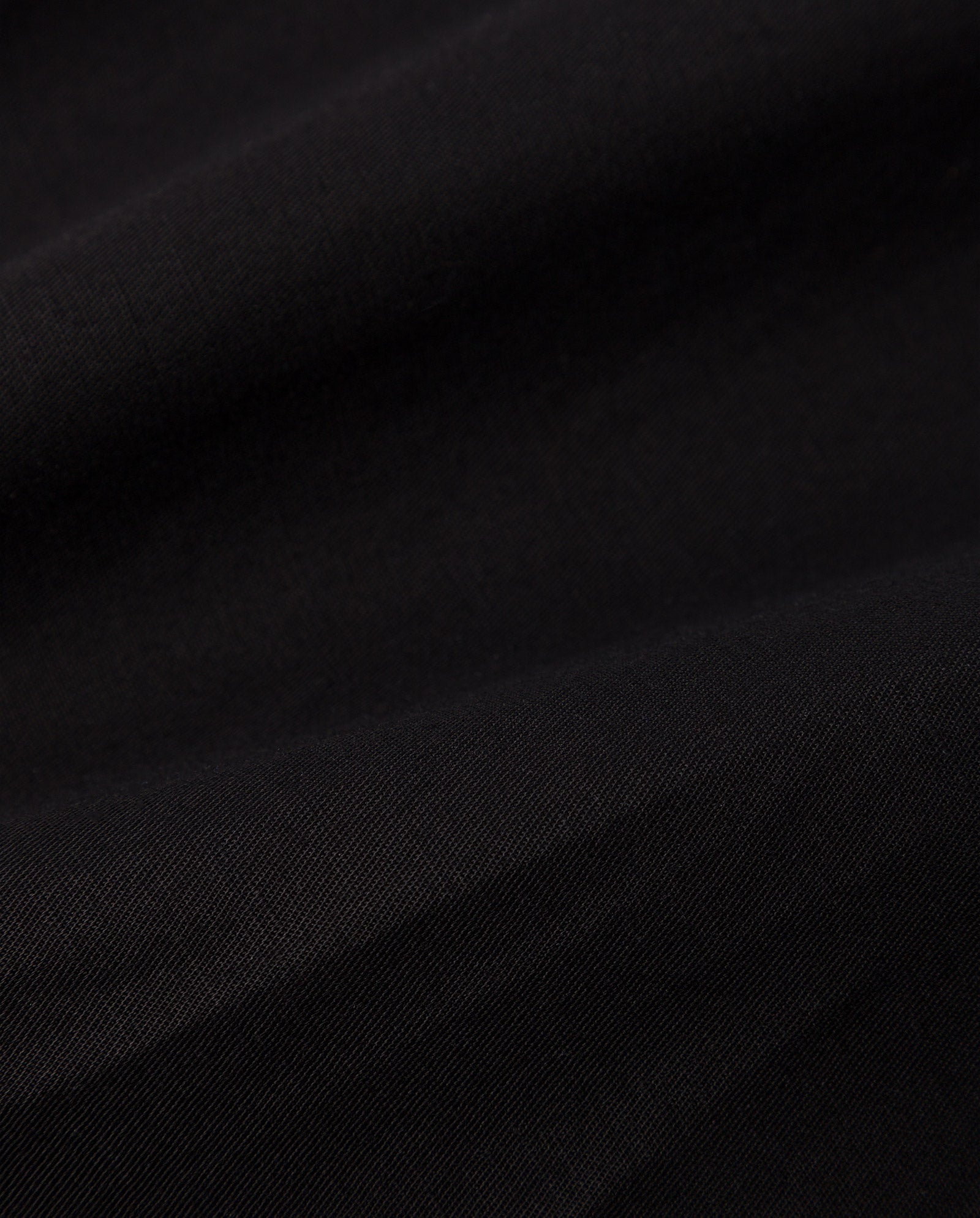 Close-up of smooth black linen blend fabric with gentle folds and soft texture, ideal for crafting the PIERA Trousers by IVY OAK.