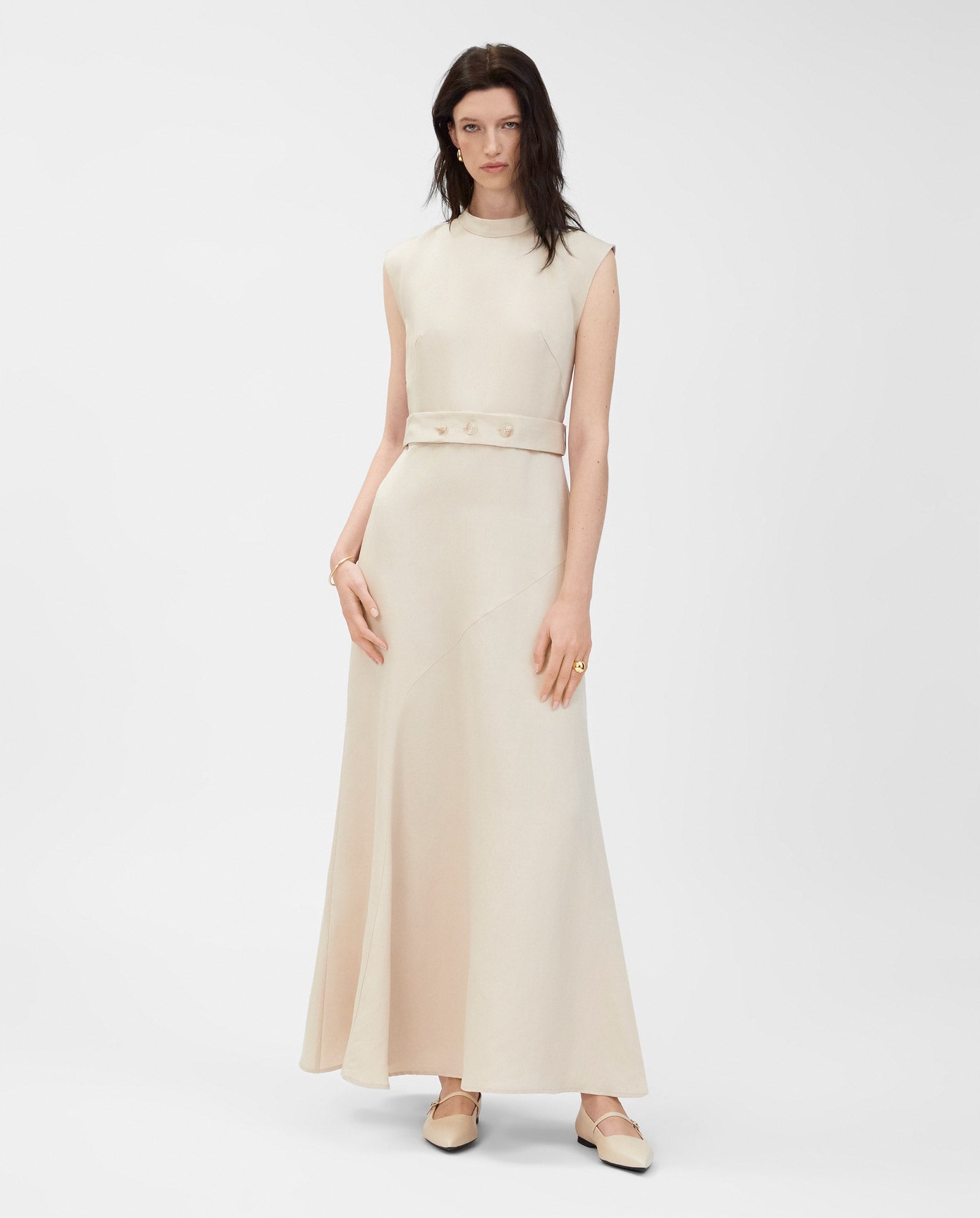 Woman in a sleeveless IVY OAK MANILA Dress, crafted from soft linen blend fabric with a matching belt, standing against a plain white background.