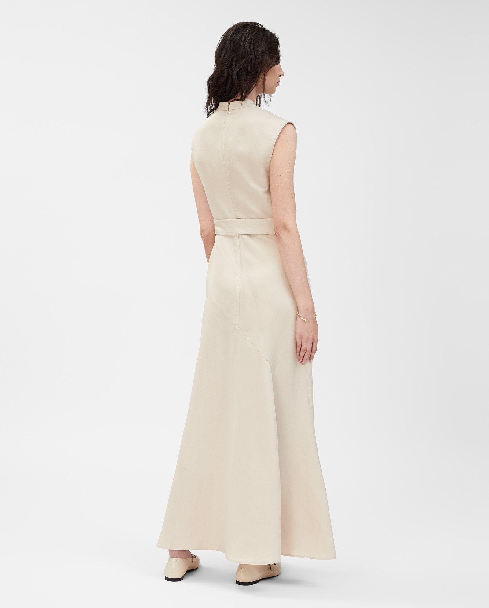 A woman, seen from behind, wears the IVY OAK MANILA Dress—a sleeveless maxi made from a linen blend—paired with light shoes.