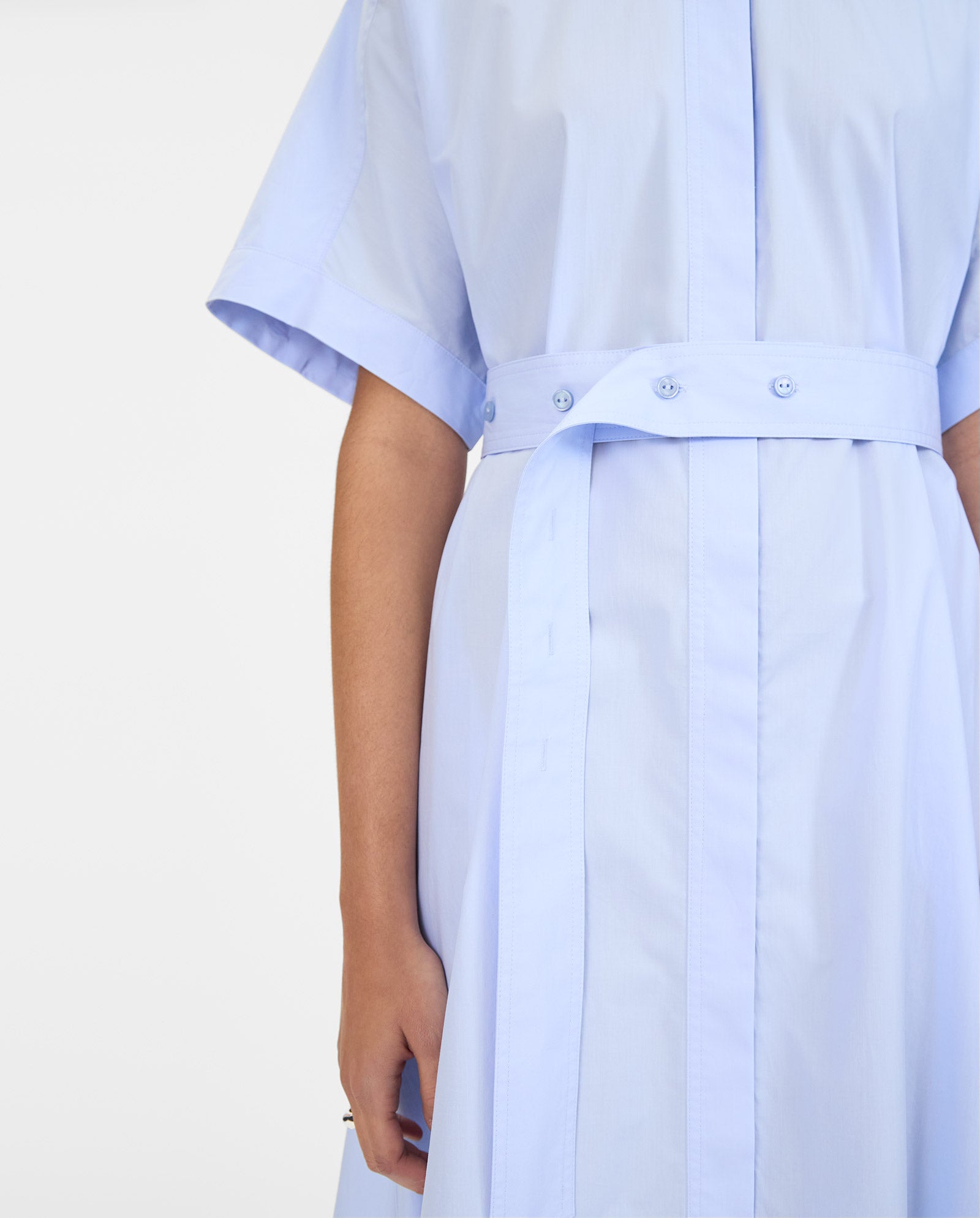 Model shown from shoulders down wearing the IVY OAK NORENA Dress in light blue, featuring a matching belted waist and short sleeves.