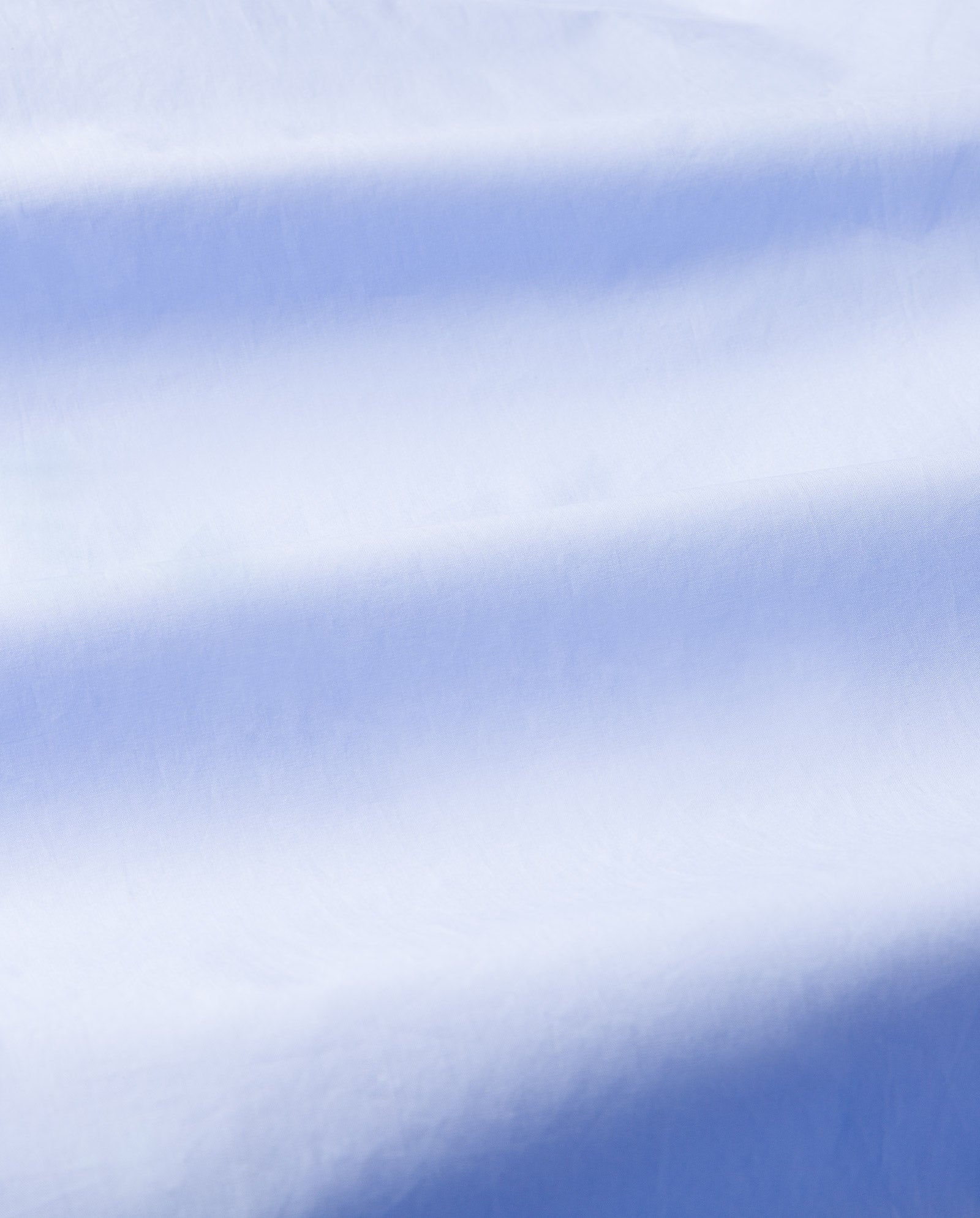 Soft white fabric with gentle folds and shadows creates a smooth, textured surface—ideal for the IVY OAK NORENA Dress, perfect as a shirt or beach dress with detachable long sleeves.