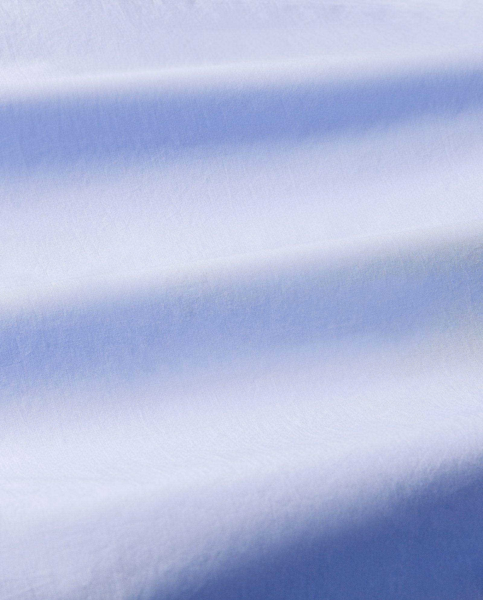 Close-up of smooth, light blue fabric with soft folds and gentle shadows—ideal for the IVY OAK NICOLINA Dress, featuring an elegant maxi length and adjustable straps.